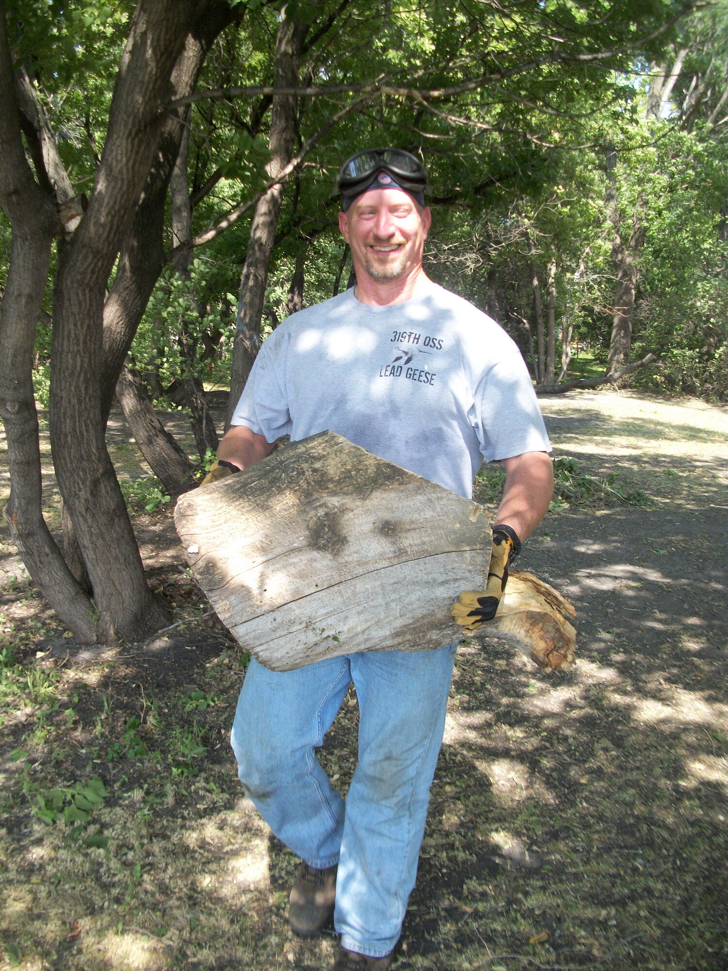 Brian Sullivan carries a large section of a tree trunk onto the back of a flatbed truck hauling piles of tree brush at Seebart Park in Emerado, N.D., on Aug. 24, 2013. Sullivan was one of seven Warriors of the North from Grand Forks Air Force Base, N.D., who volunteered to help do some landscaping as part of a beautification project for the park in the nearby town.(U.S. Air Force photo/Staff Sgt. Luis Loza Gutierrez)
