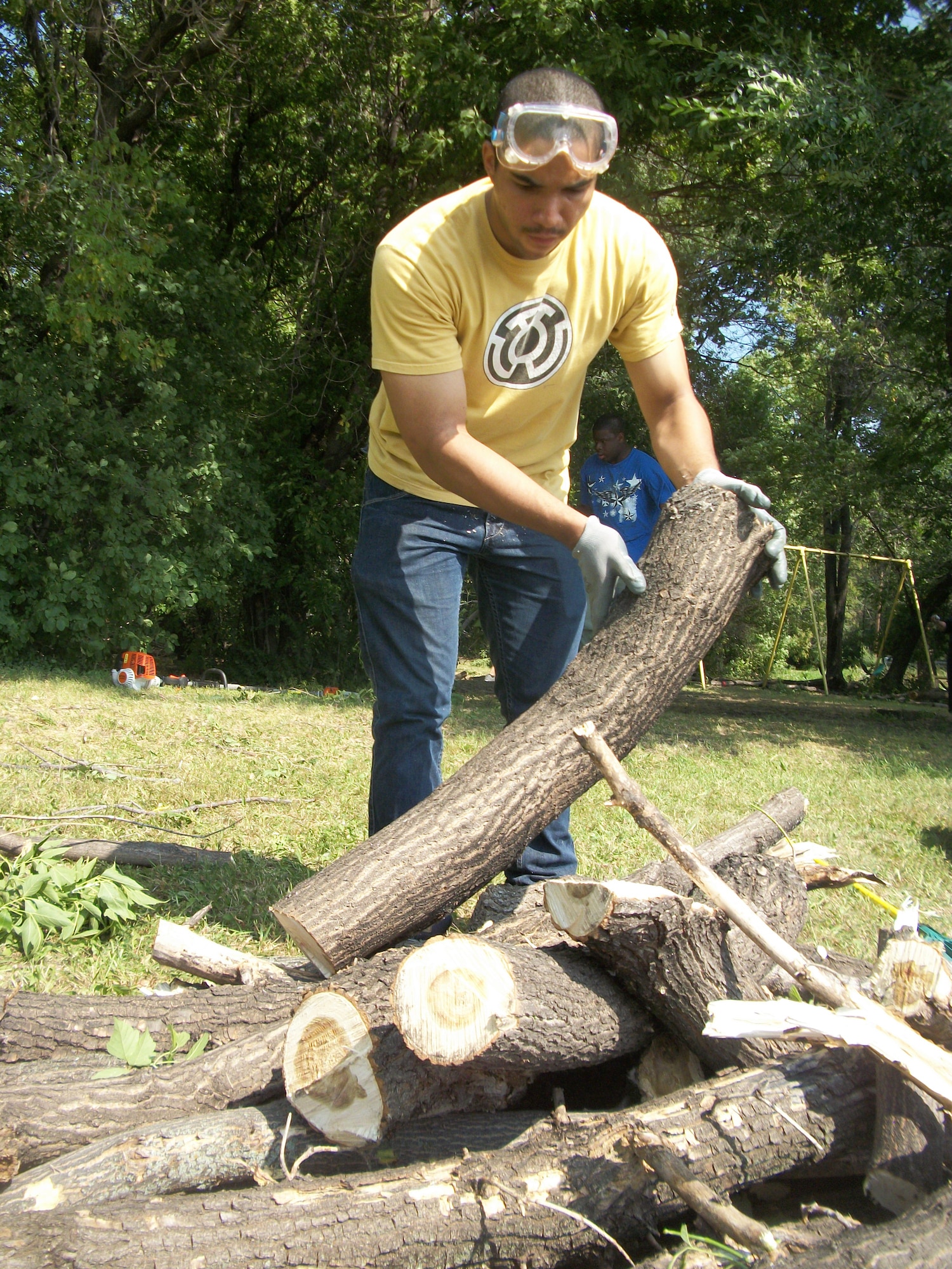Airman 1st Class Elias Rios tosses another log onto a pile at Seebart Park in Emerado, N.D., on Aug. 24, 2013. Rios was one of seven Warriors of the North from Grand Forks Air Force Base, N.D., who volunteered to help do some landscaping as part of a beautification project for the park in the nearby town.(U.S. Air Force photo/Staff Sgt. Luis Loza Gutierrez)

