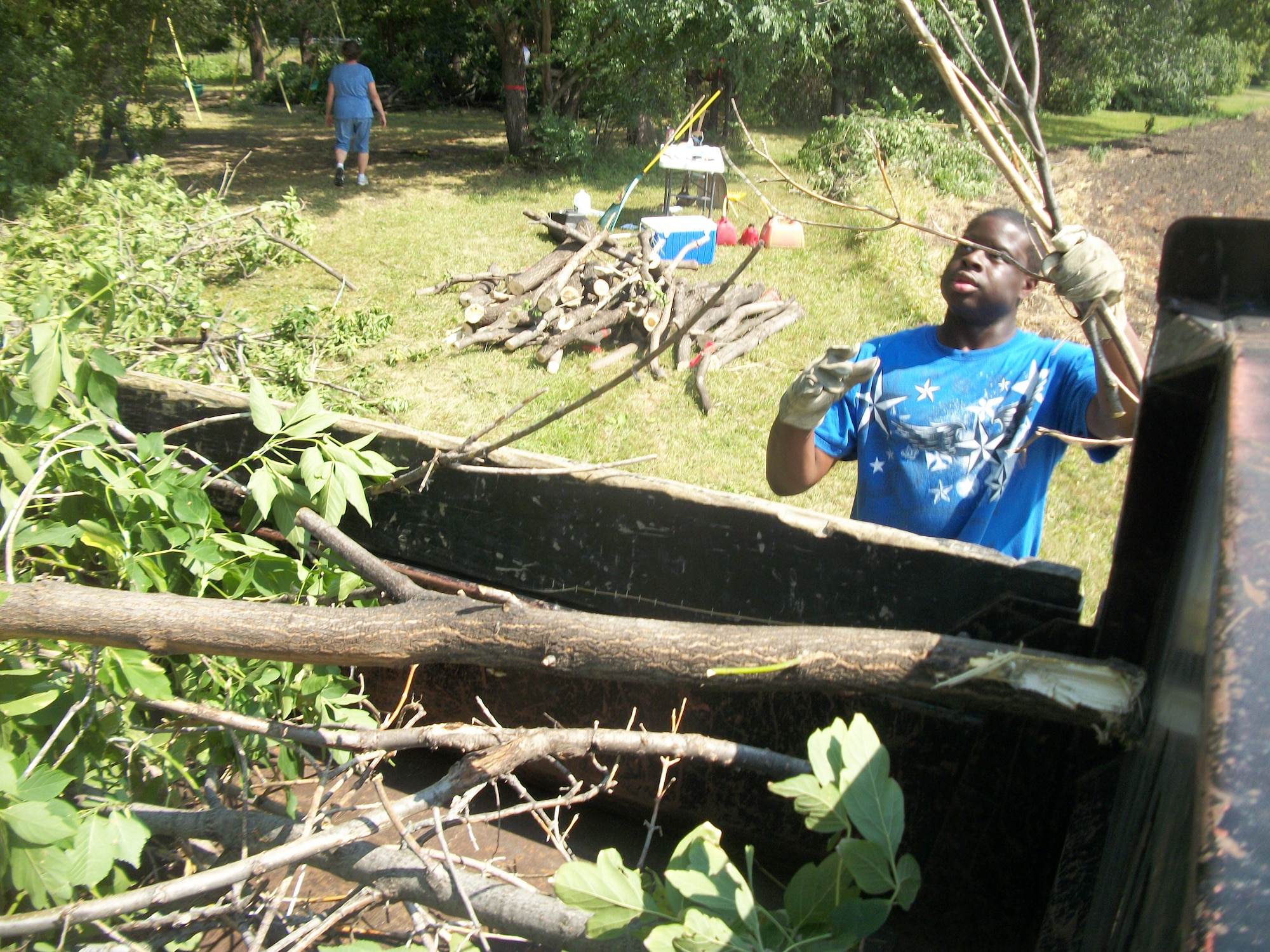 Senior Airman Devell Shanks tosses up some more branches onto another brush pile almost ready to be removed by a flatbed cargo truck at Seebart Park in Emerado, N.D., on Aug. 24, 2013. Shanks was one of seven Warriors of the North from Grand Forks Air Force Base, N.D., who volunteered to help do some landscaping as part of a beautification project for the park in the nearby town.(U.S. Air Force photo/Staff Sgt. Luis Loza Gutierrez)

