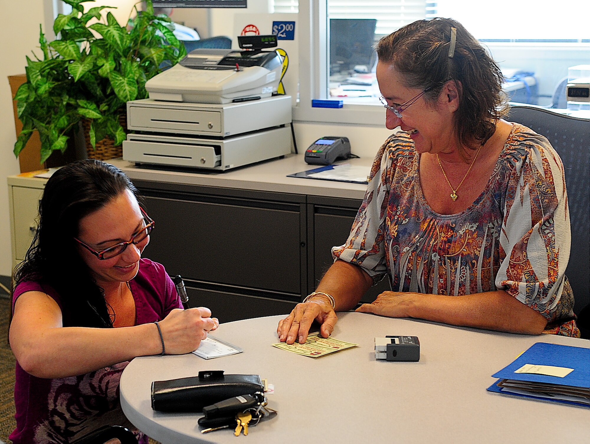 Michelle Sides purchases two movie tickets for the Dover mall from Patricia Audy, Outdoor Recreation specialist, Aug. 23, 2013, at Outdoor Recreation on Dover Air Force Base, Del. The information, travel and tickets section of Outdoor Recreation sells discounted movie tickets for the local area and amusement park tickets for the surrounding states. (U.S. Air Force photo/Airman 1st Class Ashlin Federick)