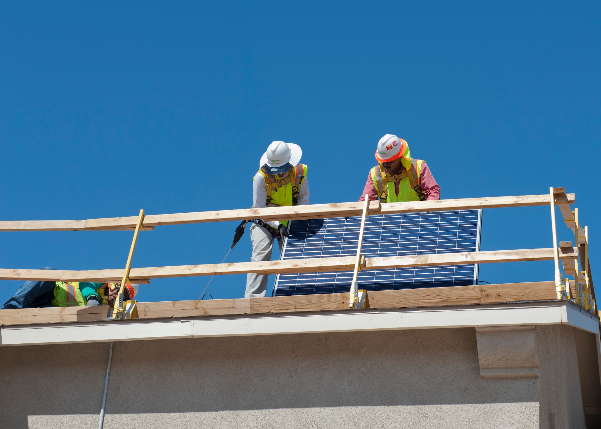 Workers prepare to install solar panels to a home at Holloman AFB, N.M., August 9th. Homes will be selected based on the amount of sun they receive, the condition of the roof and location of surrounding trees. The installation will potentially reduce the cost per kilowatt hour of energy by almost half. The project is part of the Department of Defense renewable energy plan, which will help every member of Team Holloman. (U.S. Air Force photo by Airman 1st Class Colin Cates/Released) 