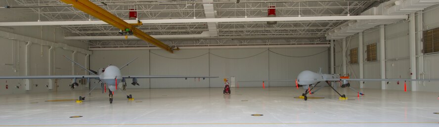 An MQ-9 Reaper and MQ-1 Predator sit on display in brand new Hangar three at Holloman Air Force Base, N.M.,  Aug. 26. Construction on hangar started May 12 and opened Aug. 22. The hangar will be used to house the MQ-1 and MQ-9 remotely piloted aircrafts that are used for worldwide-pilot training including numerous foreign services. (U.S. Air Force photo by Airman 1st Class Leah Murray/Released)