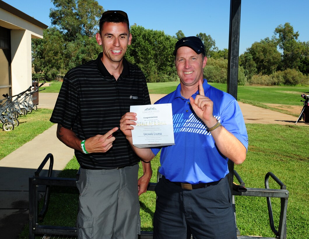 Lt. Col. John Franklin, 9th Maintenance Group deputy group commander (right), and Staff Sgt. Dennis (Bud) Holtz, 9th Maintenance Squadron aerospace ground equipment journeyman, claim their prize for winning a fundraising golf tournament at Beale Air Force Base, Calif., on Aug. 23, 2013. The tournament raised $3,000 for the Air Force Ball. (U.S. Air Force photo by Airman 1st Class Bobby Cummings/Released)