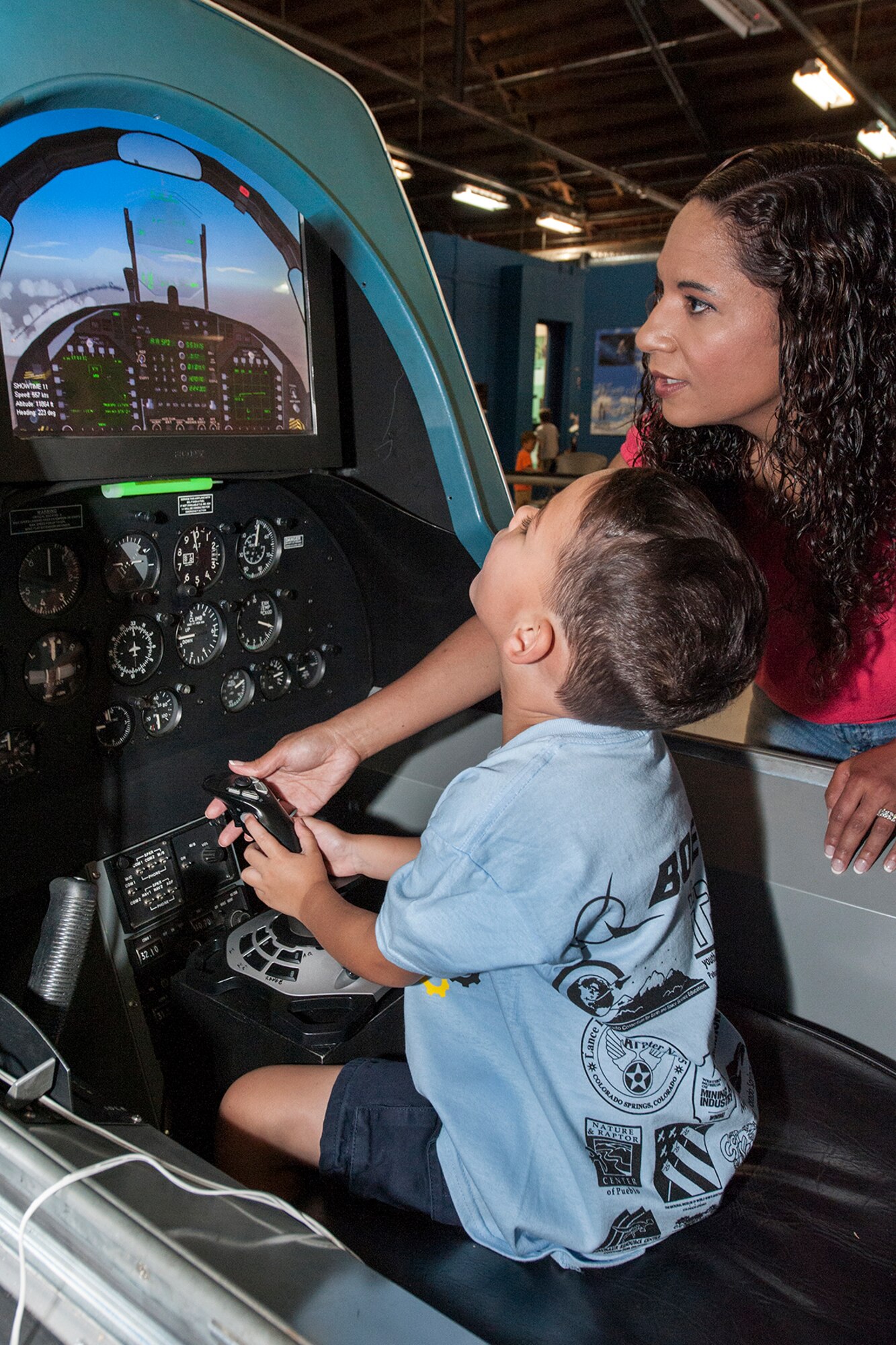 Lin Foulk assists Gabriel Foulk as he carefully pilots an aircraft high above the clouds during STEM Rocks! The festival was held at the Peterson Air and Space Museum Aug. 24 and included hands-on activities for kindergarten to eighth graders. Some of the activities involved making slime, crawling through caves, launching rockets, building gliders, electricity demonstrations, and more interactive demonstrations. (U.S. Air Force photo/Craig Denton)