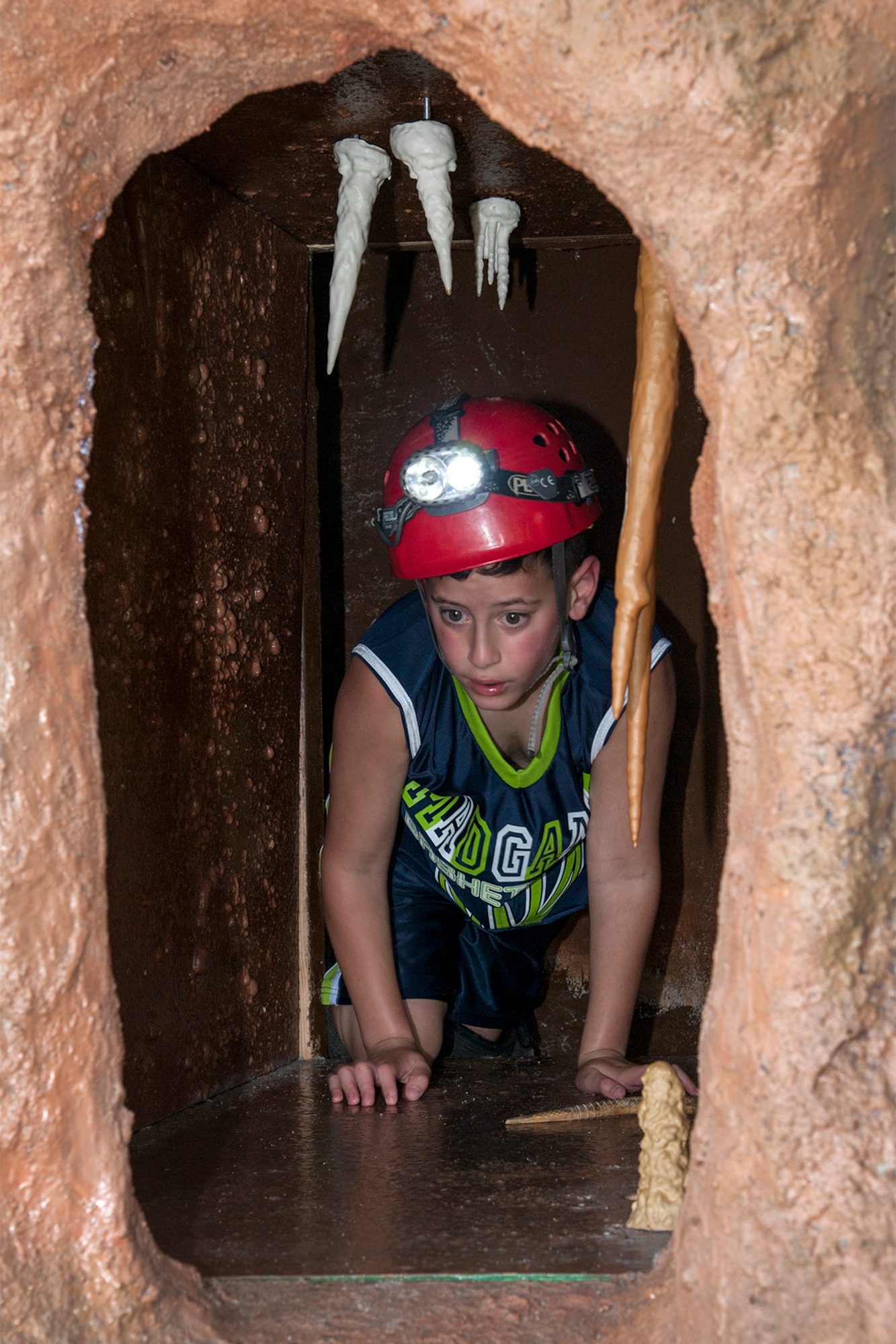 Kadin McSpadden wears a lighted helmet and other safety gear as he explores a 60 foot cave simulator complete with stalagtites and stalagmites during STEM Rocks! The festival was held at the Peterson Air and Space Museum Aug. 24 and included hands-on activities for kindergarten to eighth graders. Some of the activities involved making slime, crawling through caves, launching rockets, building gliders, electricity demonstrations, and more interactive demonstrations. (U.S. Air Force photo/Craig Denton)
