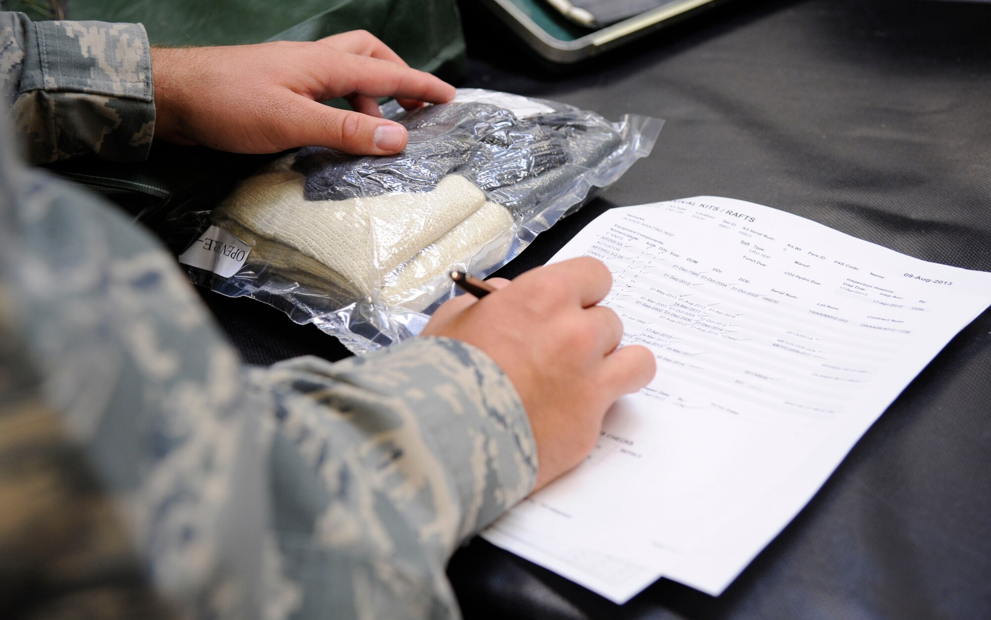 Master Sgt. Chris Scott, 2nd Operations Support Squadron NCO in-charge of Quality Assurance, checks off equipment while inspecting survival kits on Barksdale Air Force Base, La., Aug. 27, 2013. Scott's responsibilities as QA are ensuring the quality of equipment, and proper procedures are followed when kits are packed and conducting personnel evaluations to ensure Airmen receive the proper training. (U.S. Air Force photo/Airman 1st Class Andrew Moua)