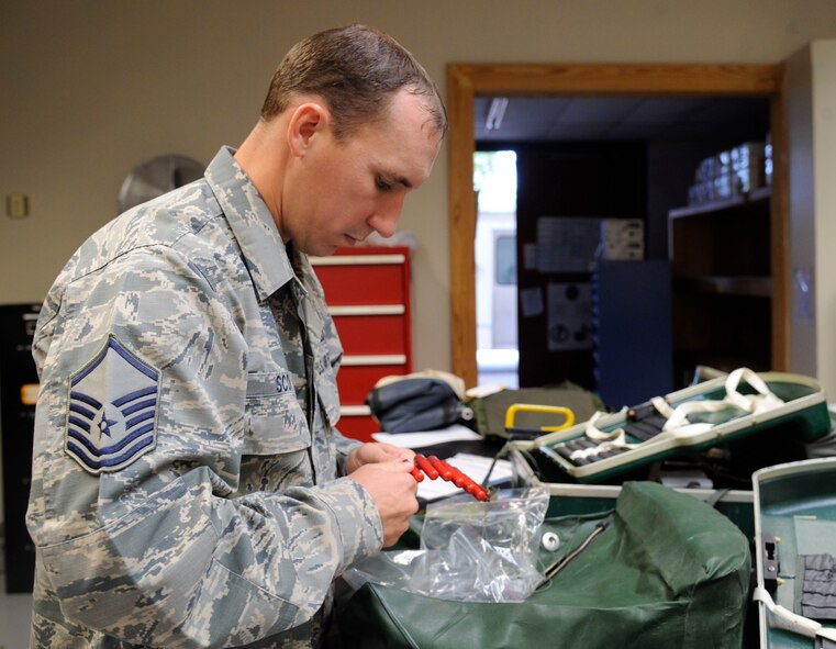 Master Sgt. Chris Scott, 2nd Operations Support Squadron NCO in-charge of Quality Assurance, inspects a personal distress signal kit on Barksdale Air Force Base, La., Aug. 27, 2013. The kit contains flares, strobe lights and special dyes for aircrew to use to aid rescue forces in locating them. (U.S. Air Force photo/Airman 1st Class Andrew Moua)