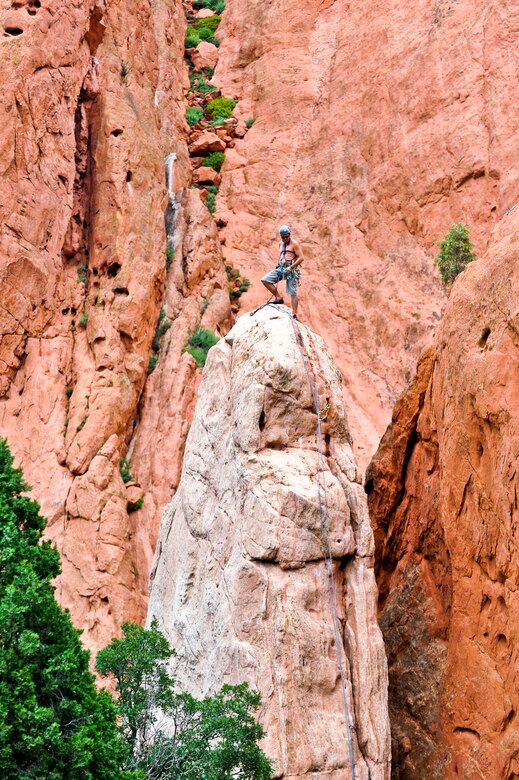 A climber stands at the summit of a stone pillar at Garden of the Gods Aug. 17, 2013, Colorado Springs, Colo. The national landmark boasts several red and white stone formations, including Cathedral Rock, Balanced Rock and Kissing Camels. Rock climbing is allowed with a permit.  (U.S. Air Force photo by Airman 1st Class Riley Johnson/Released)