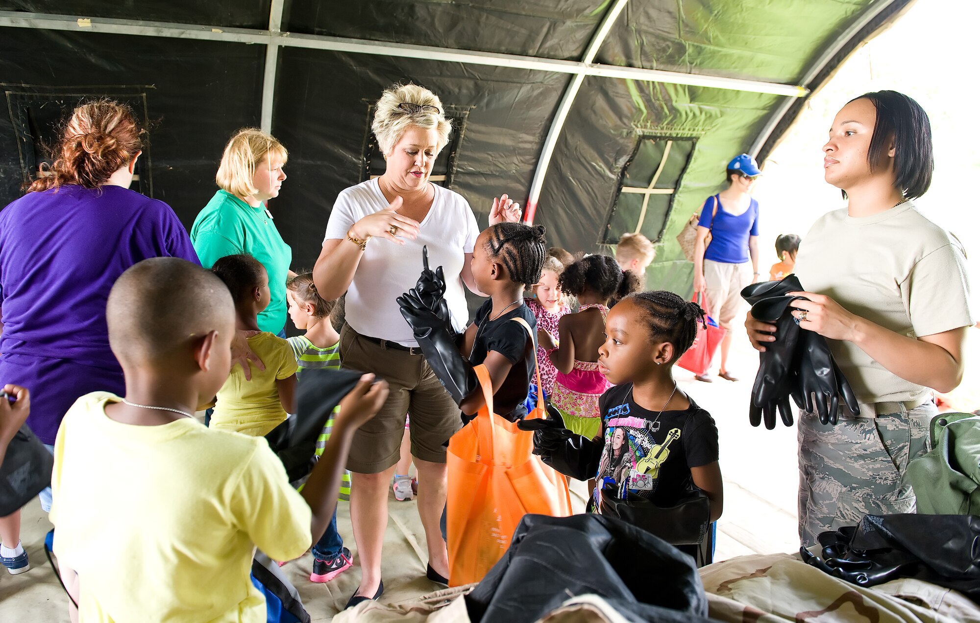 Children don chemical weapon protective gear during the children's mobility line August 22, 2013, at Dover Air Force Base, Del. Team Dover members answered questions and provided training equipment for children to try. (U.S. Air Force photo/Roland Balik)