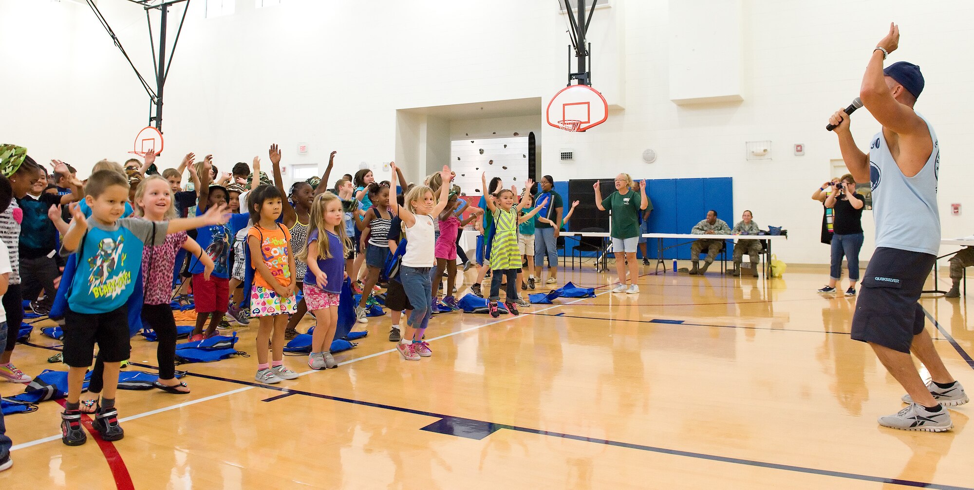 John Walters, physiologist with the Health and Wellness Center, leads children in jumping jacks prior to participating in the children's mobility line August 22, 2013, at Dover Air Force Base, Del. Walters emphasized the importance of physical fitness to mobility line participants. (U.S. Air Force photo/Roland Balik)