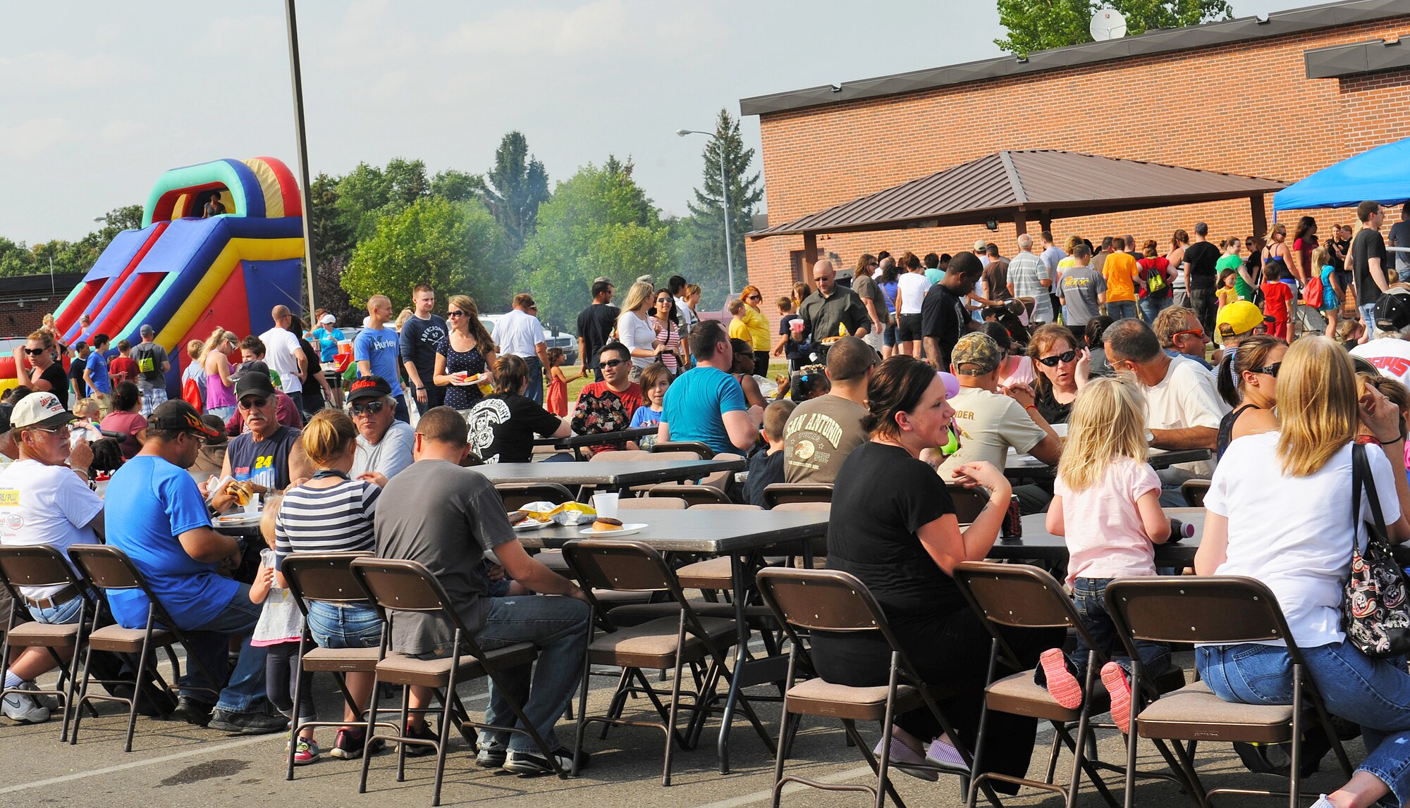 Team Minot Airmen, their families, and local community members gather at the J.R. Rockers parking lot for the end of summer Community Fair, Aug. 23, 2013. The fair, which served to provide Airmen awareness on the activities and organizations available in the local community, featured informational booths, a car show and a free barbeque. (U.S. Air Force photo/Airman 1st Class Apryl Hall)