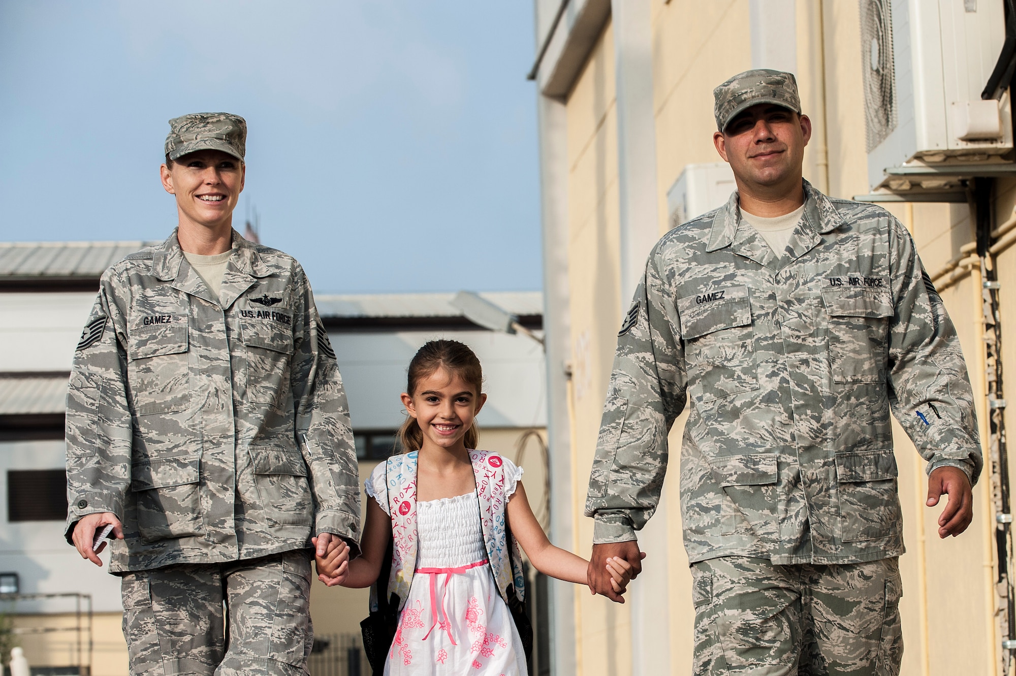 U.S. Air Force Tech. Sgt. Kelly Gamez, 39th Medical Group NCO in charge of Personnel Reliability Program and flight medicine, and Staff Sgt. Blake Gamez, 39th Logistics Readiness Squadron NCO in charge of outbound freights, walk with their daughter to her first day of school Aug. 26, 2013, Incirlik Air Base, Turkey. The first day of school is a community event at Incirlik AB, during which the wing commander welcomes the new school year with the sounding of the gong. (U.S. Air Force photo by Airman 1st Class Nicole Sikorski/Released) 