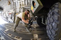 SrA. Peter Alicea-Correa, 42nd Aerial Port Squadron, ties down the 439th Airlift Control Flight's Hard-sided Expandable Lightweight Air Mobility Shelter (HELAMS) in a C-17 aircraft on August 25, 2013. Four ALCF units reserve-wide participated in an annual Air Force Reserve exercise where Airmen operated two contingency response exercises, one in Colorado Springs and another in Pueblo, Colo., with C-17 and C-130's flying between the two locations. (U.S. Air Force photo/SrA. Kelly Galloway)