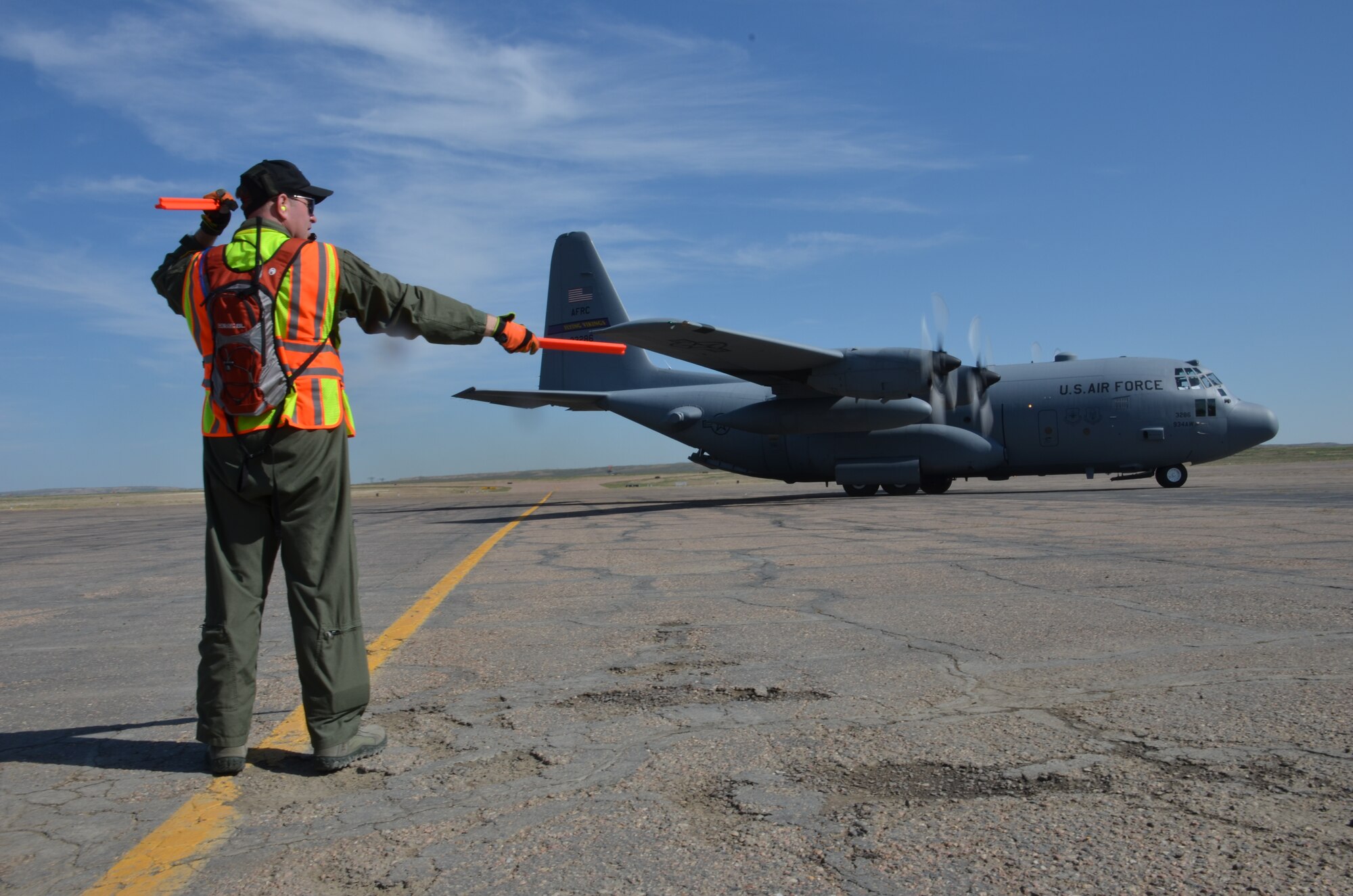 TSgt. Steve Duplessis, 439th Airlift Control Flight (ALCF) Loadmaster, marshals a C-130 to the runway in Pueblo, Colo., Aug. 24, 2013. Four ALCF units reserve-wide participated in an annual Air Force Reserve exercise where Airmen operated two contingency response exercises, one in Colorado Springs and another in Pueblo, Colo., with C-17 and C-130's flying between the two locations. (U.S. Air Force photo/SrA. Kelly Galloway)