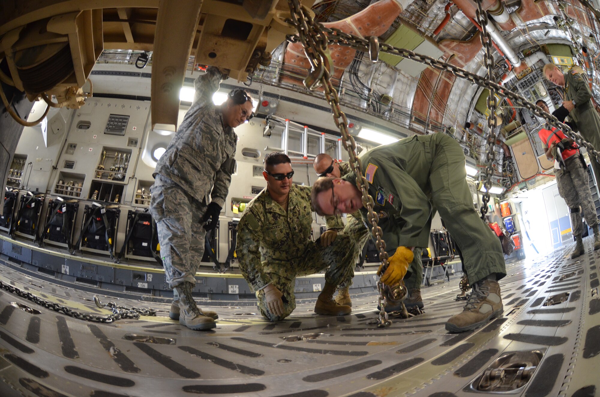 SMSgt. Paul Johnson, 317th Airlift Squadron, instructs members of the Naval Mobile Construction Battalion 17 in Colorado Springs, Colo., Aug. 24, on how to properly tie-down cargo during the annual AFRC-sponsored air mobility exercise, "Patriot Express." The ALCF is responsible for the training of Air Force and sister service units on how to move by air. They instruct over 400 units in preparing and loading their mobility equipment for air shipment. (U.S. Air Force photo/SrA. Kelly Galloway) 