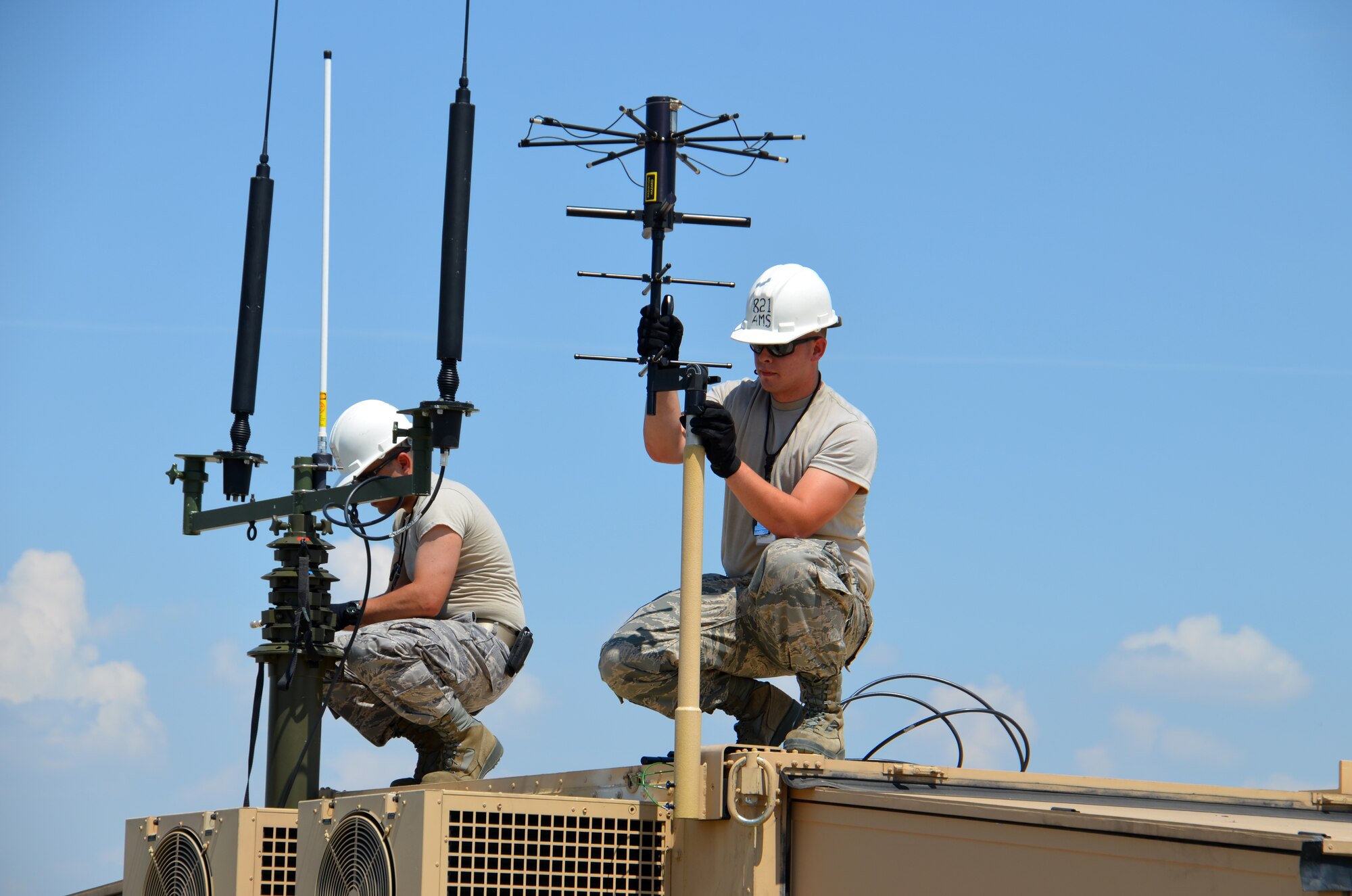 TSgt. Lui Puga and SrA. Kyle Gauthier, 439th Airlift Control Flight communications, prepare the antenna's atop the Hard-sided Expandable Lightweight Air Mobility Shelter in Pueblo, Colo., Aug. 22, just before the start of the annual AFRC-sponsored air mobility exercise, "Patriot Express." The ALCF is responsible for the training of Air Force and sister service units on how to move by air. They instruct over 400 units in preparing and loading their mobility equipment for air shipment. (U.S. Air Force photo/SrA. Kelly Galloway) 