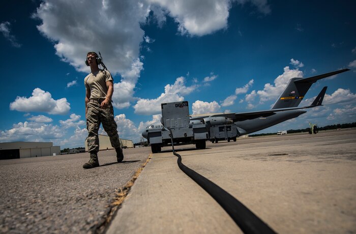 Senior Airman Cody Richman, 437th Aircraft Maintenance Squadron C-17 Globemaster III flying crew chief, sets up a generator to power a C-17 Aug. 12, 2013, at Joint Base Charleston – Air Base, S.C. The generator supplies the aircraft with power so Richman can perform his routine inspections. (U.S. Air Force photo/ Senior Airman Dennis Sloan)