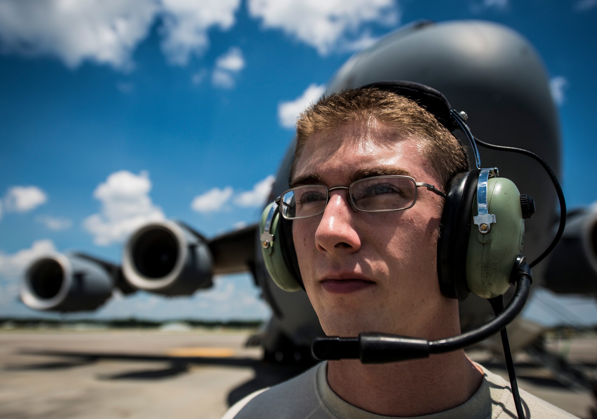 Senior Airman Cody Richman, 437th Aircraft Maintenance Squadron C-17 Globemaster III flying crew chief, wears a head set allowing him to communicate with aircrew members inside the cockpit of the aircraft Aug. 12, 2013, at Joint Base Charleston – Air Base, S.C. Richman ensures the aircraft is working properly and safe to fly at a moment’s notice. (U.S. Air Force photo/ Senior Airman Dennis Sloan)