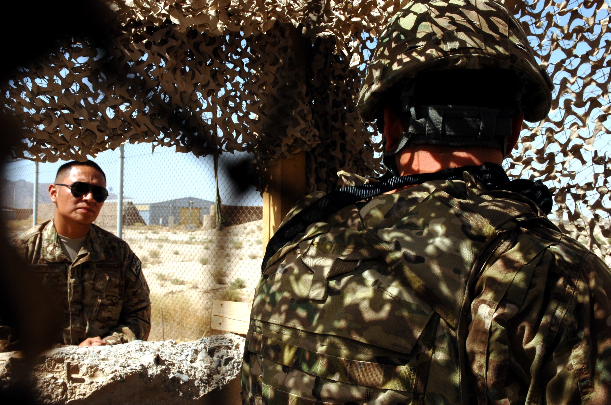 Staff Sgt. Brandon Etsitty, 451st Air Expeditionary Wing force protection, questions Airman 1st Class Ty Cole, 451st Expeditionary Maintenance Squadron, about force protection procedures during an exercise at Kandahar Airfield, Afghanistan, Aug. 22, 2013. Force protection procedures provide guidance for Airmen during crises. Etsitty is deployed from Lackland Air Force Base, Texas, and Cole is deployed from Spangdahlem Air Base, Germany. (U.S. Air Force photo by Senior Airman Jack Sanders)   