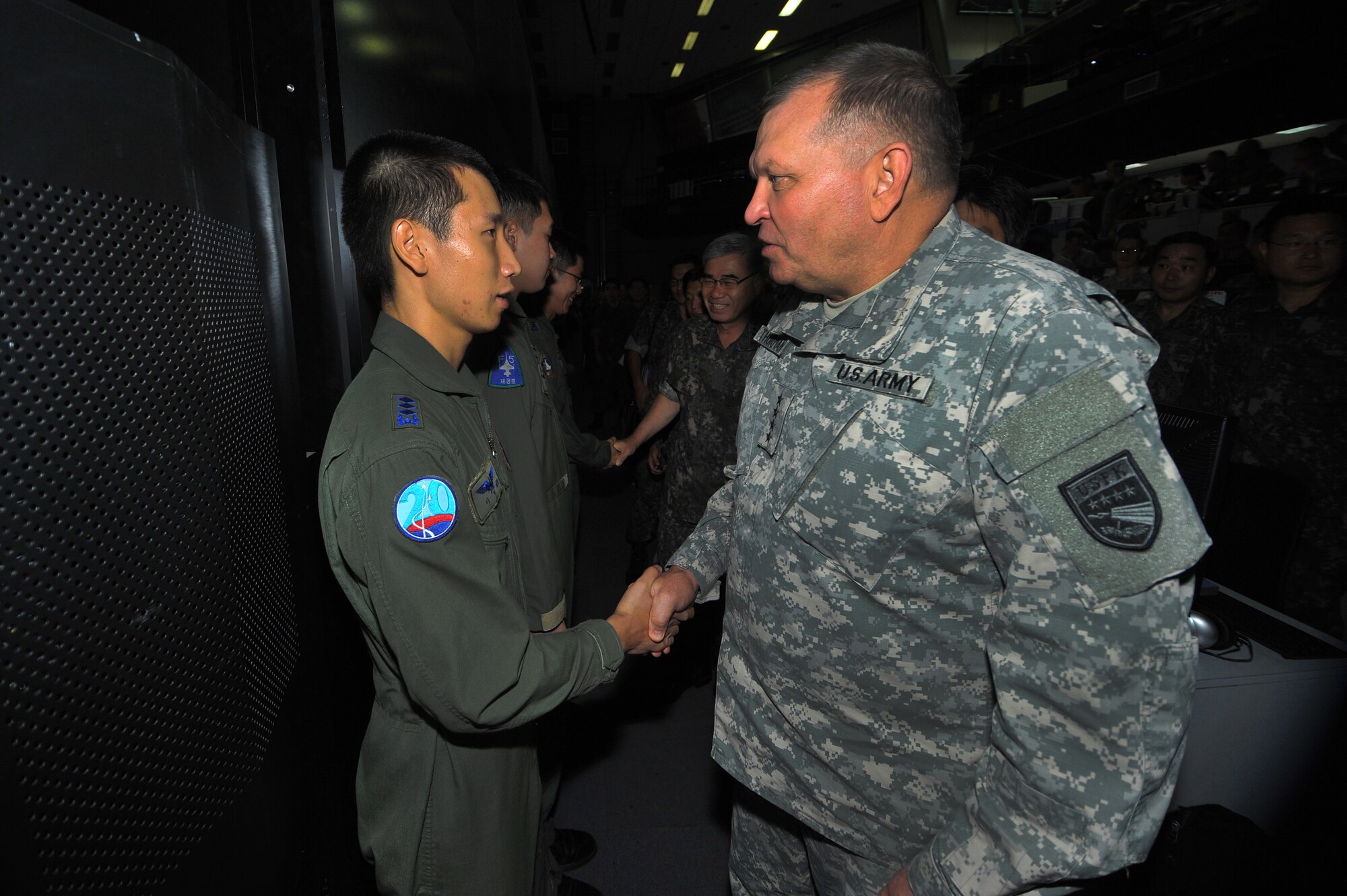 Republic of Korea Airman receives a coin from Gen. James Thurman, U.S. Forces Korea commander, during a visit to the Air Operations Center 2013 at Osan Air Base, Republic of Korea, Aug. 26, 2013 during exercise Ulchi Freedom Guardian.  UFG, held annually, highlights the longstanding military partnership, commitment and enduring friendship between the two nations, help to ensure stability and security on the peninsula and reaffirm the United States’ commitment to the Northeast Asia region. (U.S. Air Force photo/Staff Sgt. Emerson Nuñez)