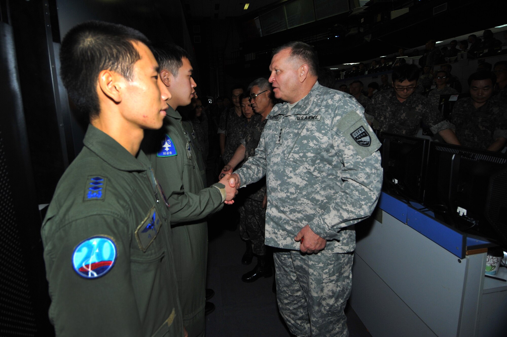 Republic of Korea Airman receives a coin from Gen. James Thurman, U.S. Forces Korea commander, during a visit to the Air Operations Center 2013 at Osan Air Base, Republic of Korea, Aug. 26, 2013 during exercise Ulchi Freedom Guardian. UFG is a critical alliance exercise to sustain the readiness of the ROK, U.S. forces and sending state forces. (U.S. Air Force photo/Staff Sgt. Emerson Nuñez)