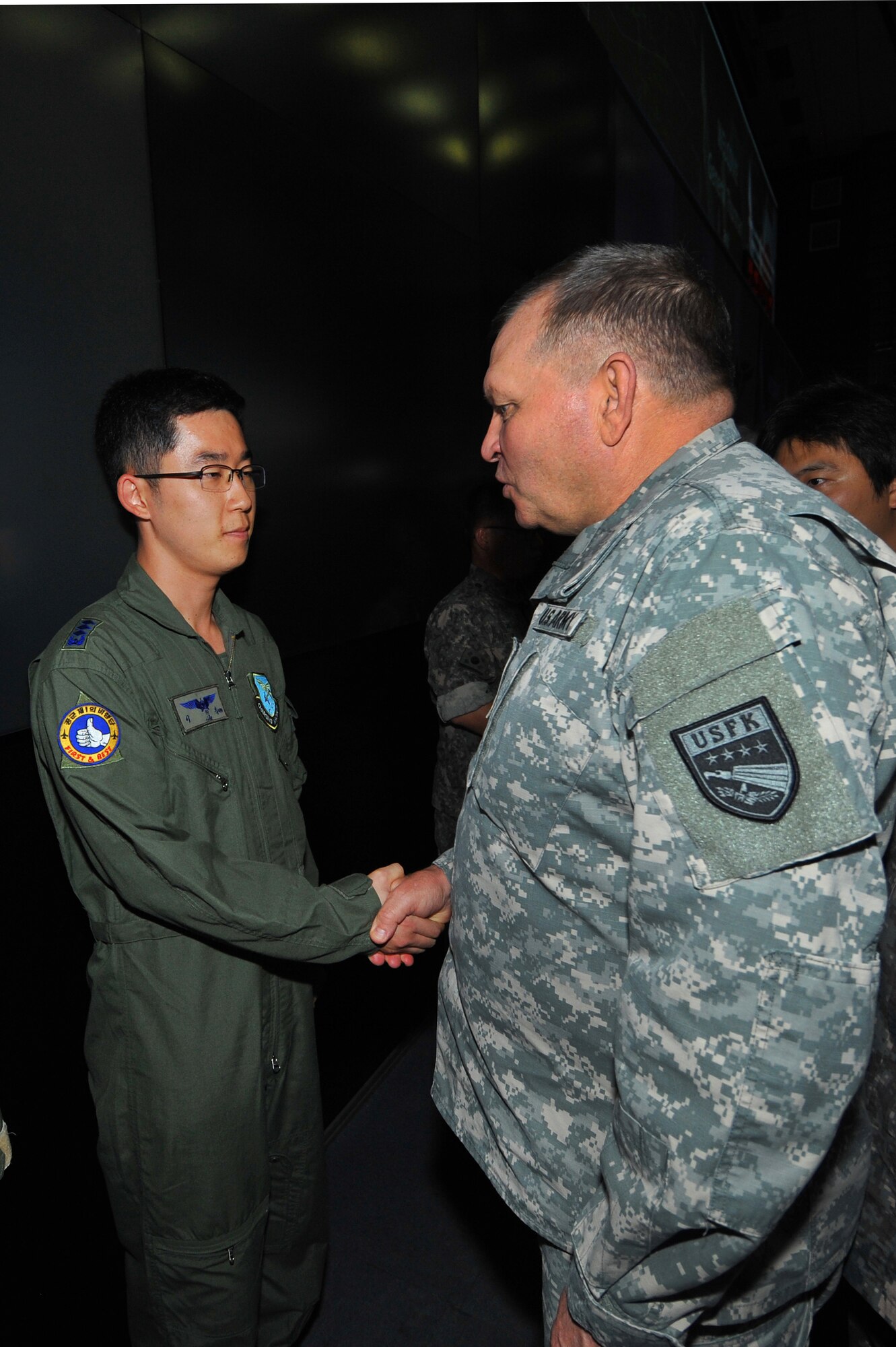 Republic of Korea Airman receives a coin from Gen. James Thurman, U.S. Forces Korea commander, during a visit to the Air Operations Center 2013 at Osan Air Base, Republic of Korea, Aug. 26, 2013 during exercise Ulchi Freedom Guardian. The annual exercise, conducted by the ROK and U.S. Combined Forces Command, runs through Aug. 30. (U.S. Air Force photo/Staff Sgt. Emerson Nuñez)