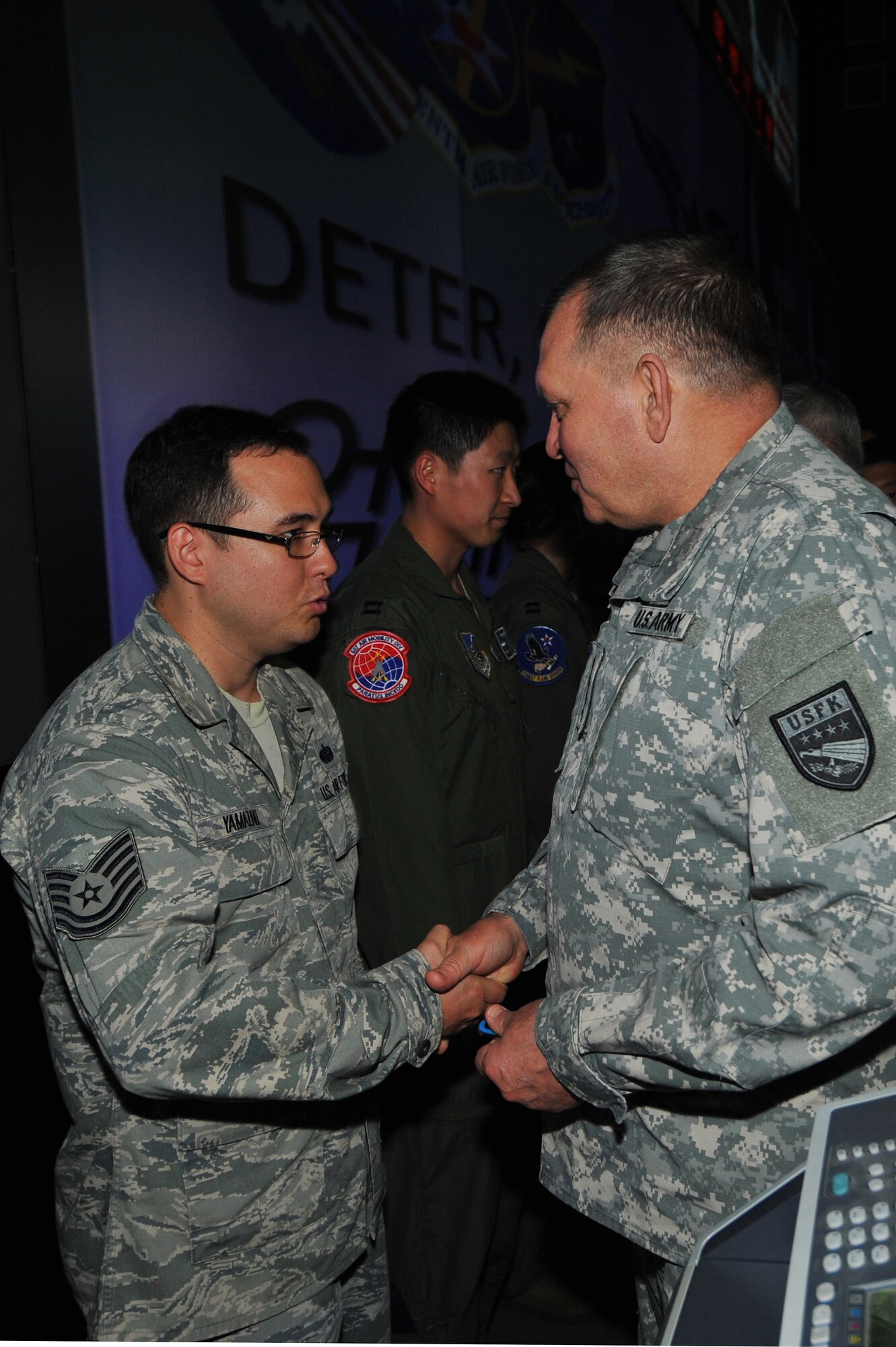 Tech. Sgt. Toshiaki Yamazaki, 607th Support Squadron commanders controller NCOIC, receives a coin from Gen. James Thurman, U.S. Forces Korea commander, during a visit to the Air Operations Center 2013 at Osan Air Base, Republic of Korea, Aug. 26, 2013 during exercise Ulchi Freedom Guardian.  UFG, held annually, highlights the longstanding military partnership, commitment and enduring friendship between the two nations, help to ensure stability and security on the peninsula and reaffirm the United States’ commitment to the Northeast Asia region. (U.S. Air Force photo/Staff Sgt. Emerson Nuñez)