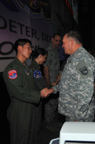 Capt. Matle Yan, 607th Air Mobility Division member, receives a coin from Gen. James Thurman, U.S. Forces Korea commander,  during a visit to the Air Operations Center 2013 at Osan Air Base, Republic of Korea, Aug. 26, 2013 during exercise Ulchi Freedom Guardian.  The annual exercise, conducted by the ROK and U.S. Combined Forces Command, runs through Aug. 30. (U.S. Air Force photo/Staff Sgt. Emerson Nuñez)