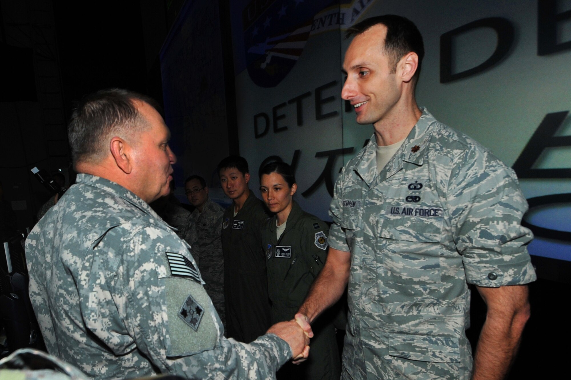 Maj. Shawn Stappen, 7th AF Air Force Staff of Operations staff member, receives a coin from Gen. James Thurman, U.S. Forces Korea commander, during a visit to the Air Operations Center 2013 at Osan Air Base, Republic of Korea, Aug. 26, 2013 during exercise Ulchi Freedom Guardian. UFG is a critical alliance exercise to sustain the readiness of the ROK, U.S. forces and sending state forces. (U.S. Air Force photo/Staff Sgt. Emerson Nuñez)
