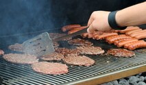 A volunteer flips burgers during a Hearts Apart gathering hosted by the Airmen and Family Readiness Center Aug. 23, 2013, on Andersen Air Force Base, Guam. Families of deployed service members attended to connect with and support each other while their Airmen are deployed. (U.S. Air Force photo by Airman 1st Class Amanda Morris/Released)