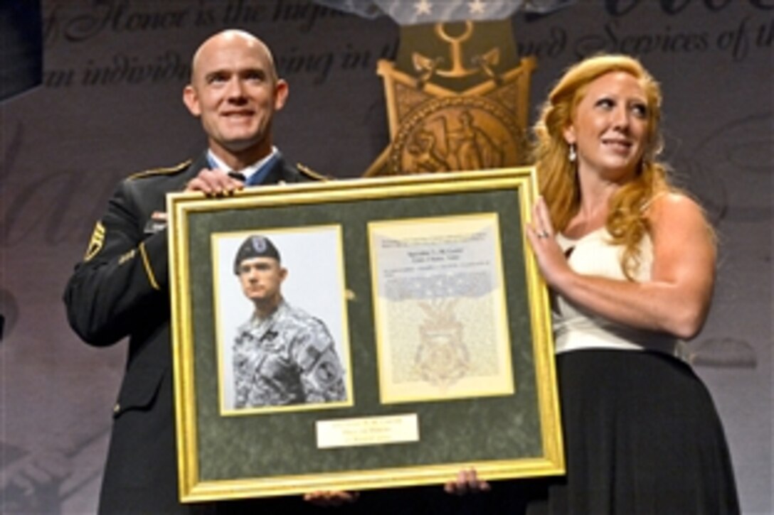 Medal of Honor recipient Army Staff Sgt. Ty Michael Carter and his wife, Shannon, receive a plaque as he is honored during a ceremony at the Pentagon, Aug. 27, 2013. Deputy Defense Secretary Ash Carter, not pictured, hosted the event for the soldier, the fifth living recipient of the military's top honor, for his valor on Combat Outpost Keating, Afghanistan, Oct. 3, 2009.