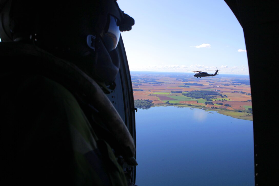 Giving full, 360-degree situational awareness to his pilots, Swedish Sgt. David Fredrikson, a UH-60 Black Hawk mission specialist with Swedish Air Force 21st UH-60 Black Hawk Helicopter Wing, relays the location of the lead aircraft after a final capabilities exercise during a Forward Air Controller (Airborne) military engagement between U.S. Marines and the Swedish Air Force. Marine aviation instructors from Marine Air Weapons and Tactics Squadron One, Yuma, Ariz., introduced Forward Air Controller (Airborne) and Close Air Support concepts, tactics, and procedures for evaluation into the Swedish Air Force’s aviation training with SwAF pilots from the 21st UH-60 Black Hawk Helicopter Wing and the JAS-39 Gripen Operations, Tactics and Evaluations division, August 5-23 at Malmen Military Base, Linköping, Sweden.