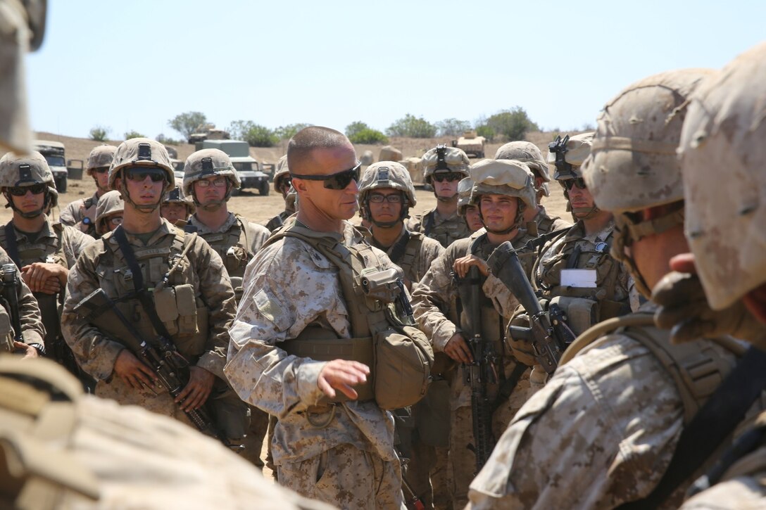 Colonel Stephen Liszewski, commanding officer, 11th Marine Regiment, briefs Marines serving with India Battery, 1st Battalion, 11th Marines, on their performance during a 10-day artillery training exercise here, Aug. 23, 2013. Marines with the entire regiment conducted the live-fire training exercise from Aug. 19 through 28.