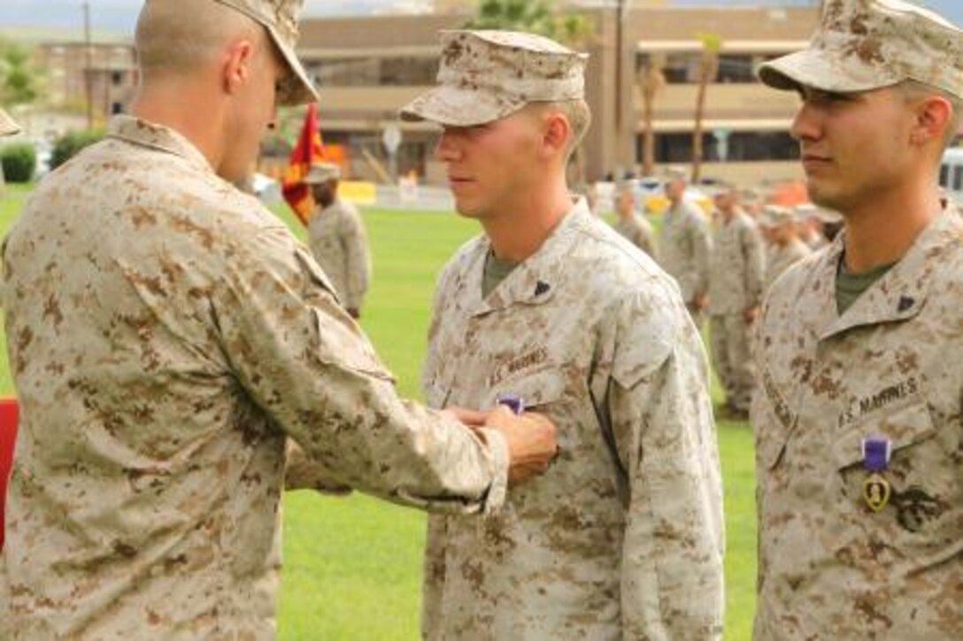 Lance Cpl. Phillip Cutler, infantryman, 2nd Battalion, 7th Marine Regiment is pinned with a Purple Heart medal at Lance Cpl. Torrey L. Gray Field Aug. 26, 2013. The Marines earned the medals for their actions while deployed to Afghanistan in support of Operation Enduring Freedom. The Marines' resistant, ambush-protected vehicle was hit by an 80-pound improvised explosive device Feb. 2, 2013. “The Purple Heart was established by Gen. George Washington and is a very respected medal,” Smith said. “We have a lot of good Marines in this unit and we will continue to do what we are trained to do.”


