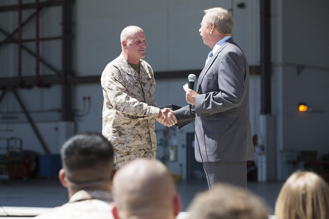 Raymond Fajay, the Director of US Government Air Mobility Business Development for Lockheed Martin Aeronautic Company congratulates Maj. Gen. Steven Busby, 3rd Marine Aircraft Wing commanding general for the stellar performance and contributions of his KC-130J squadron aboard Marine Corps Air Station Miramar, Calif. Aug. 27. The Marines of Marine Aerial Refueler Transport Squadron 352 received a limited edition medallion housed in a display case for helping the  C-130J Program’s worldwide fleet meet the million flight hour mark.