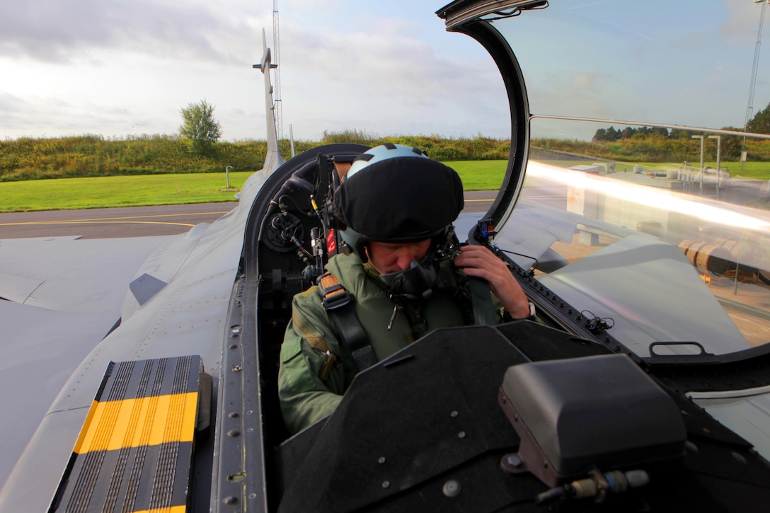 Maj. Eric Grunke, an AV-8B Harrier instructor pilot, Marine Aviation Weapons and Tactics Squadron One, Yuma, Ariz., and Weiser, Idaho, native, straps on his aviator helmet and checks his communications before support a rehearsal of Close Air Support and Forward Air Controller (Airborne) operations with Swedish aviators from the Swedish Air Force Operation, Tactics and Procedures division and SwAF UH-60 Black Hawk Helicopters from the 21st Black Hawk Helicopter Wing. Marine aviation instructors from MAWTS-1 introduced Forward Air Controller (Airborne) and Close Air Support concepts, tactics, and procedures for evaluation into the Swedish Air Force’s aviation training with SwAF pilots from the 21st UH-60 Black Hawk Helicopter Wing and the JAS-39 Gripen Operations, Tactics and Evaluations division, August 5-23 at Malmen Military Base, Linköping, Sweden.
