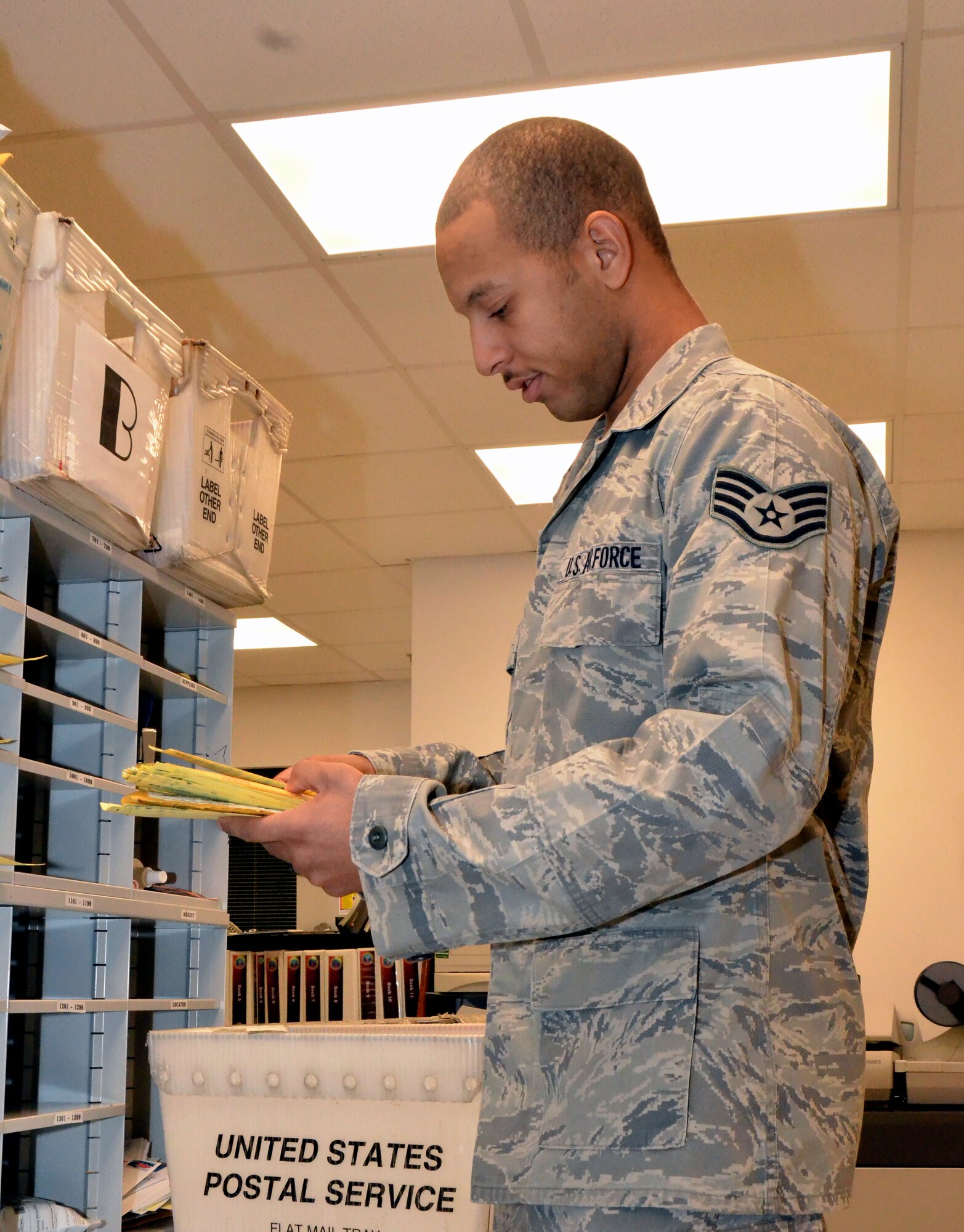 Staff Sgt. Brandon Gordon, 36th Communications Squadron postal clerk, distributes package notification slips to customers’ mailboxes on Andersen Air Force Base, Guam, Aug. 26, 2013. The five Airmen who make up the military postal section of the Andersen Post Office sort through approximately 5,000 pounds of mail each month, with a large amount of that going to the dorm residents. (U.S. Air Force photo by Airman 1st Class Mariah Haddenham/Released)