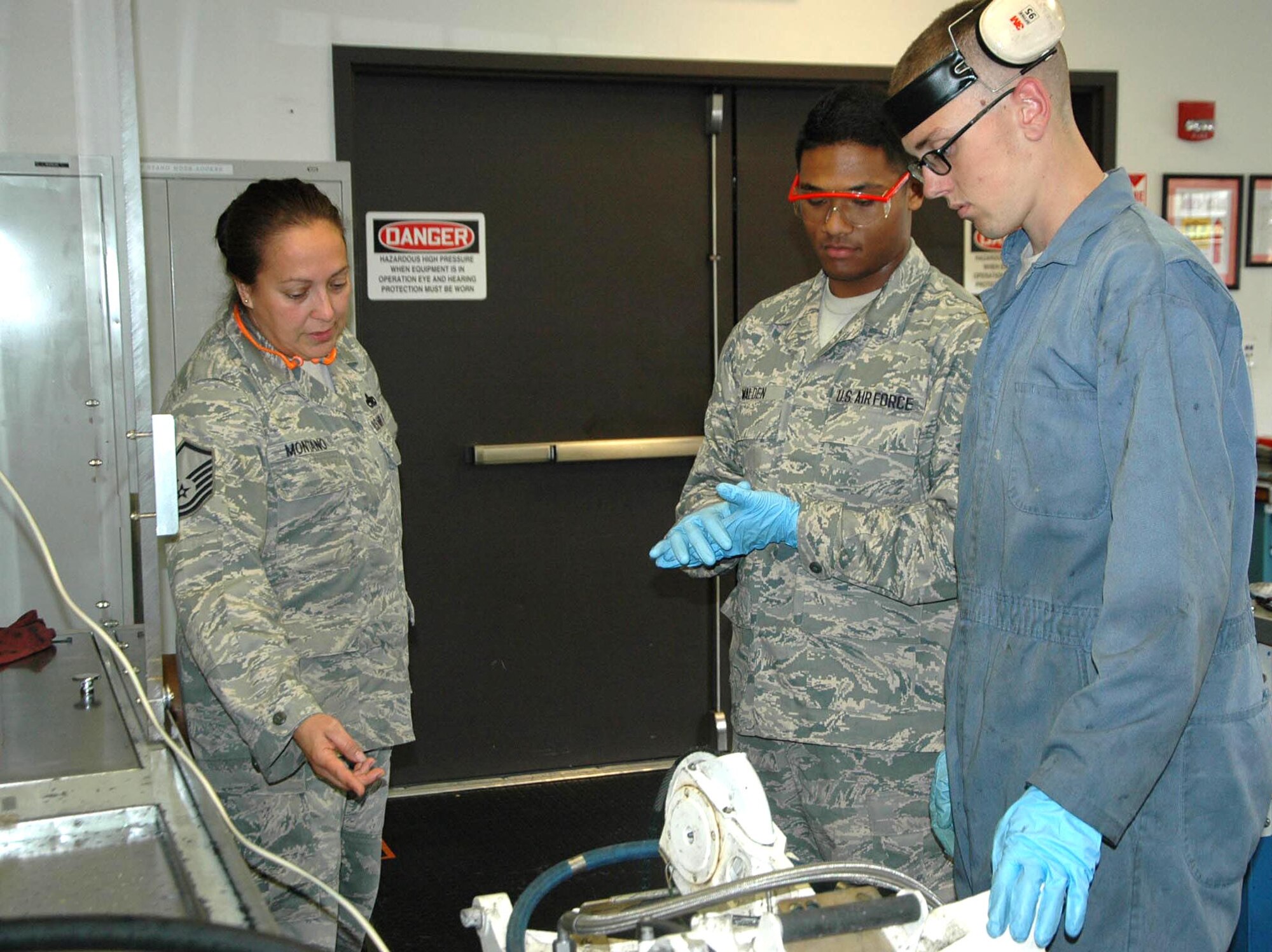 Master Sgt. Valerie Montano, 446th Maintenance Squadron, hydraulics section chief(left to right), reviews the work of Senior Airman Joshua Walden, 446th MXS, and Senior Airman Sean Thompson, 62nd Maintenance Squadron.  Walden is gaining skills in hydraulics under the seasoning training program. (U.S. Air Force Reserve photo by Sandra Pishner)