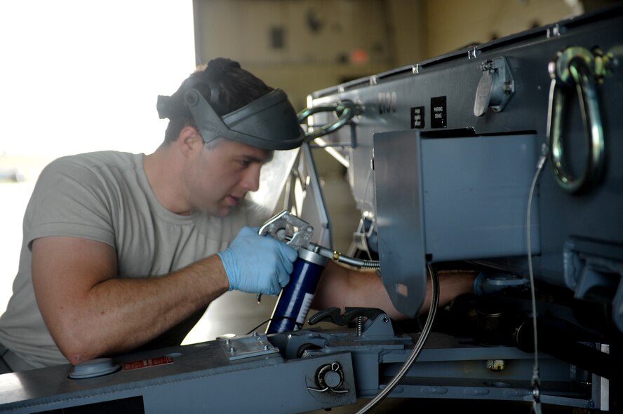 Senior Airman Nathan Kern, 28th Munitions Squadron equipment maintenance crew chief, lubricates joints on a munitions trailer at the equipment maintenance shop on Ellsworth Air Force Base, S.D., Aug. 20, 2013. It is essential to properly lubricate the trailers to prevent parts from wearing due to friction (U.S. Air Force photo by Airman 1st Class Rebecca Imwalle)