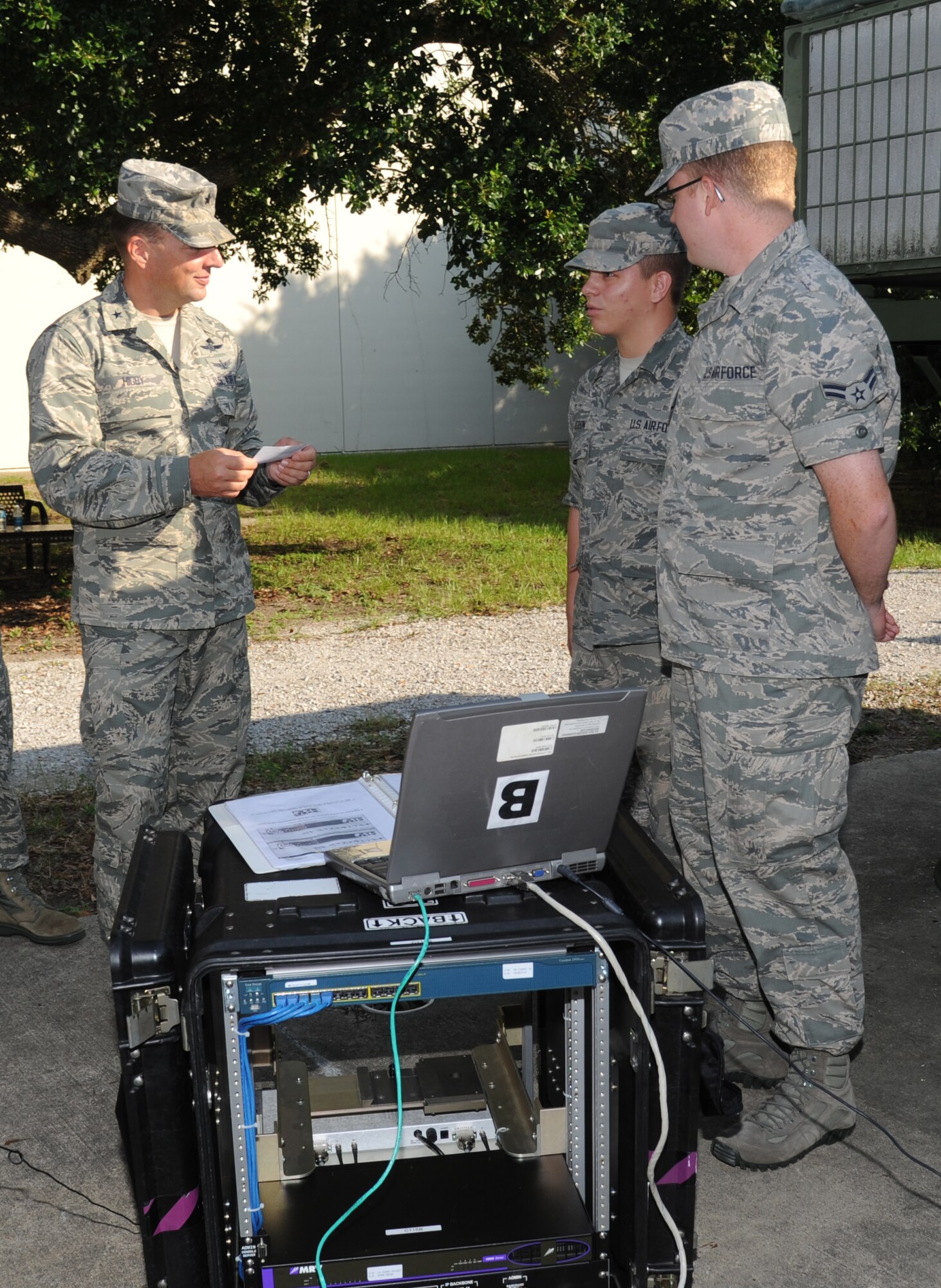 Brig. Gen. Patrick Higby, 81st Training Wing commander, tests the knowledge of Airmen 1st Class Anthony Patron and  Thomas Smith, 338th Training Squadron, with questions about the radio frequency transmissions course equipment they train with during his two-day immersion tour of the 81st Training Group Aug. 26-27, 2013, outside of Jones Hall, Keesler Air Force Base, Miss.  The purpose of the tour was to learn the integration of the group’s mission, operations and personnel. Higby will continue his tour with the 81st Medical Group, 81st Mission Support Group and Wing Staff Agencies over the next couple of weeks.  (U.S. Air Force photo by Kemberly Groue)