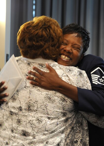 After being offically retired from military service Master Sgt. Quiltina Smith, a former Air Force    representative at the National Defense University, Fort McNair, D.C., hugs one of her guests during the Air Force District of Washington bi-montly retirement ceremony Aug. 27, 2013, at The Club on Joint Base Anacostia-Bolling, D.C. Smith enlisted in the Air Force in 1993. (U.S. Air Force photo by Tech. Sgt. Tammie Moore)