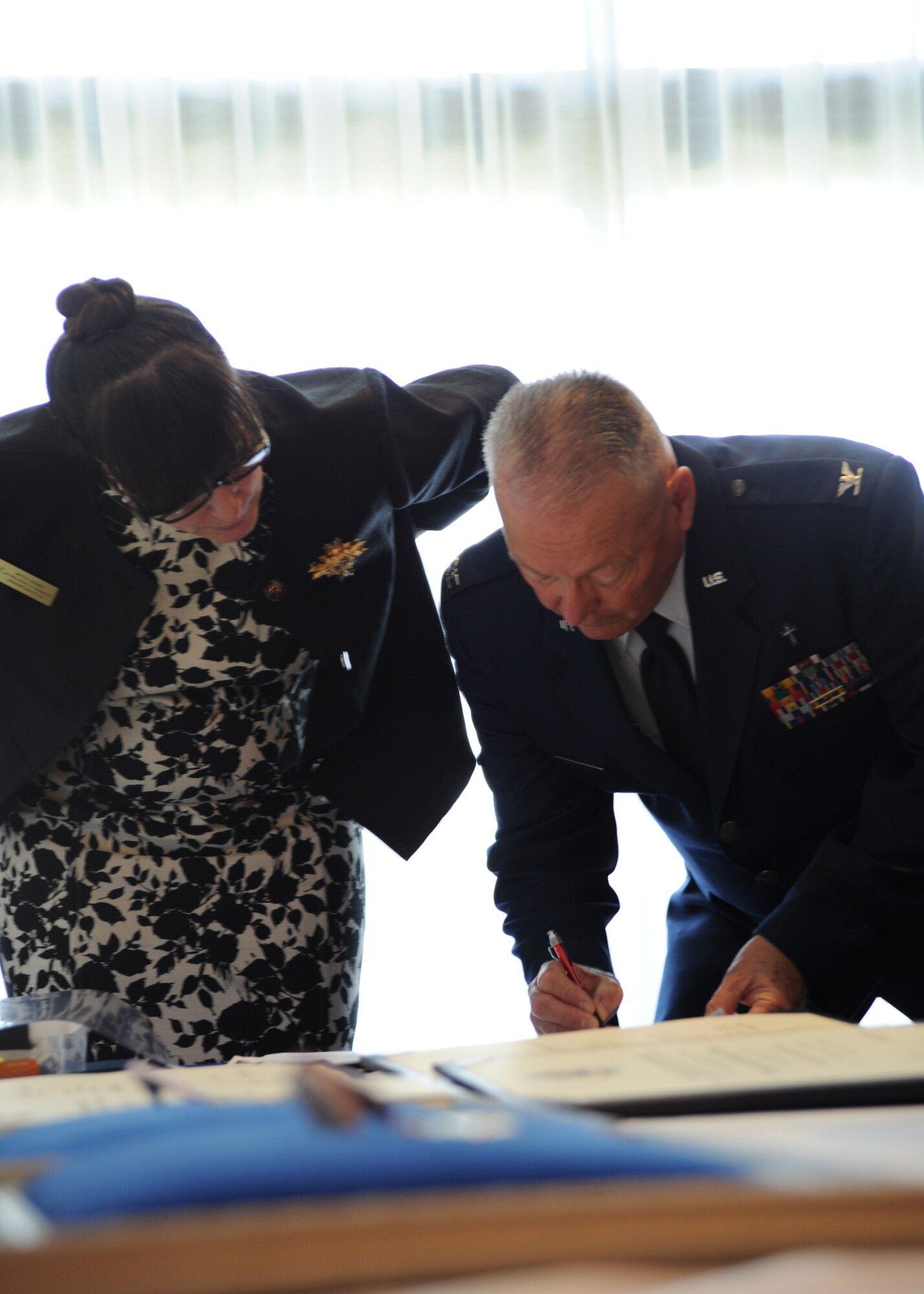Betsy Adams, Air Force District of Washington protocol deputy director, and Col. (Chap.) David Fitz-Patrick, AFDW chaplain, review information before the the command’s bi-montly retirement ceremony Aug. 27, 2013, at The Club on Joint Base Anacostia-Bolling, D.C. According to the retiree’s wishes Fitz-Patrick opened the ceremony with a prayer. (U.S. Air Force photo by Tech. Sgt. Tammie Moore)