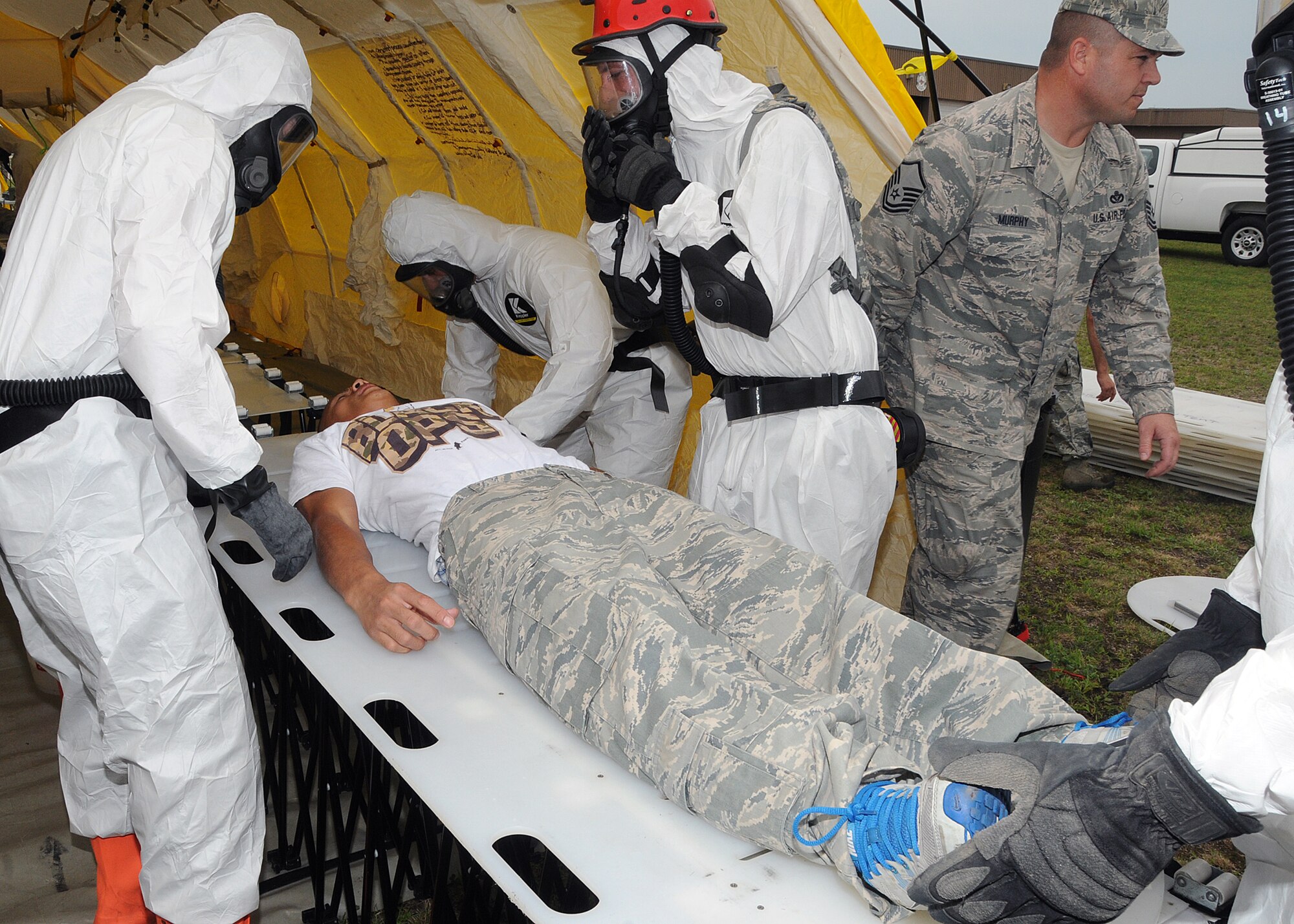 Members of the 143d Airlift Wing involved in the Region 1 Chemical, Biological, Radiological, Nuclear, High Yield Explosive Enhanced Response Force Package (CERFP) perform a training exercise to demonstrate the team's responsibilities and capabilities to potential new members and leadership. A member of the RIANG Student Flight (on stretcher) volunteered to play a victim for the exercise. The Region 1 CERFP is made up of members of the Air and Army National Guard from Maine, New Hampshire, and Rhode Island. National Guard Photo by Master Sgt Janeen Miller (RELEASED)