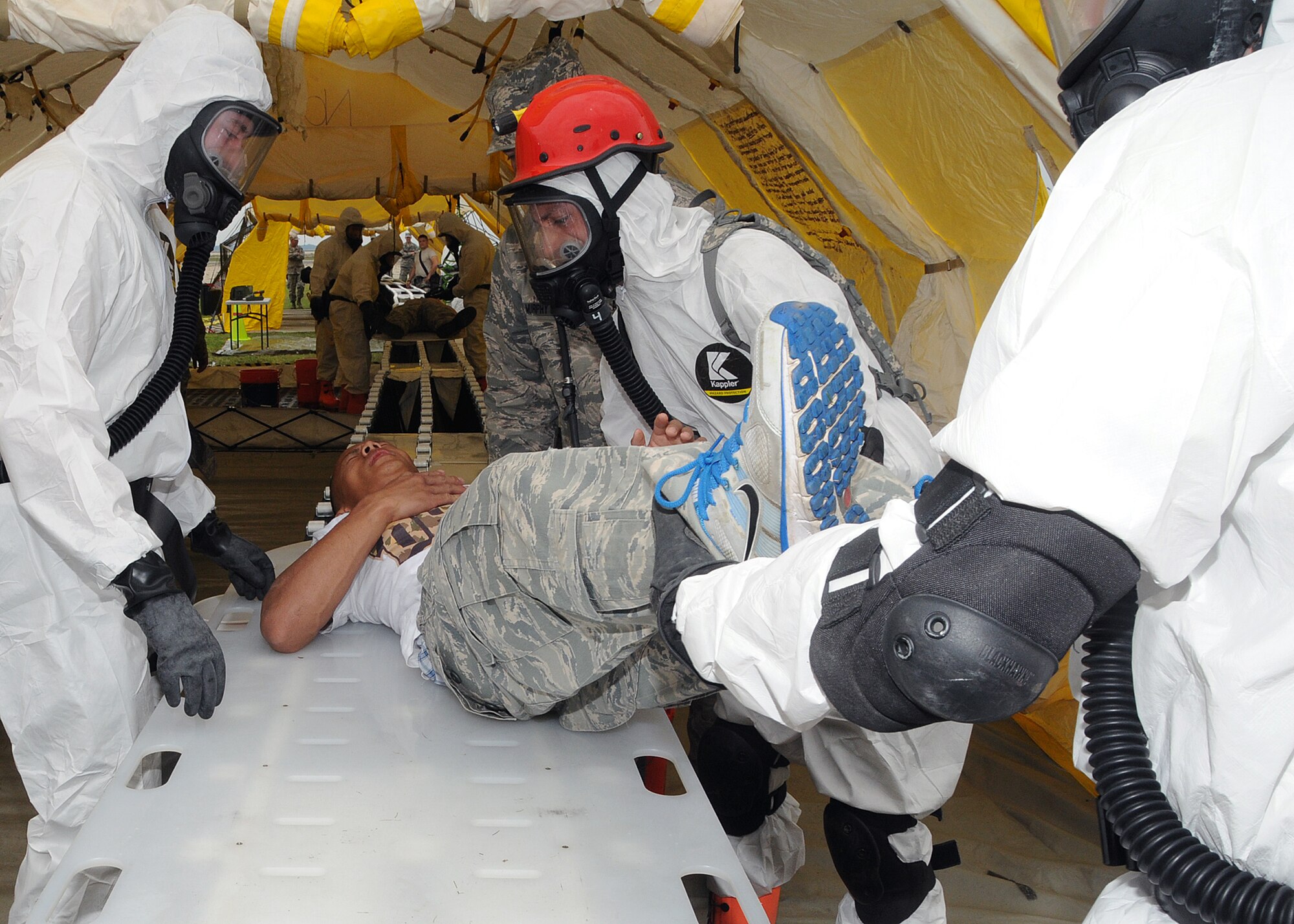 Members of the 143d Airlift Wing involved in the Region 1 Chemical, Biological, Radiological, Nuclear, High Yield Explosive Enhanced Response Force Package (CERFP) perform a training exercise to demonstrate the team's responsibilities and capabilities to potential new members and leadership. A member of the RIANG Student Flight (on stretcher) volunteered to play a victim for the exercise. The Region 1 CERFP is made up of members of the Air and Army National Guard from Maine, New Hampshire, and Rhode Island. National Guard Photo by Master Sgt Janeen Miller (RELEASED)