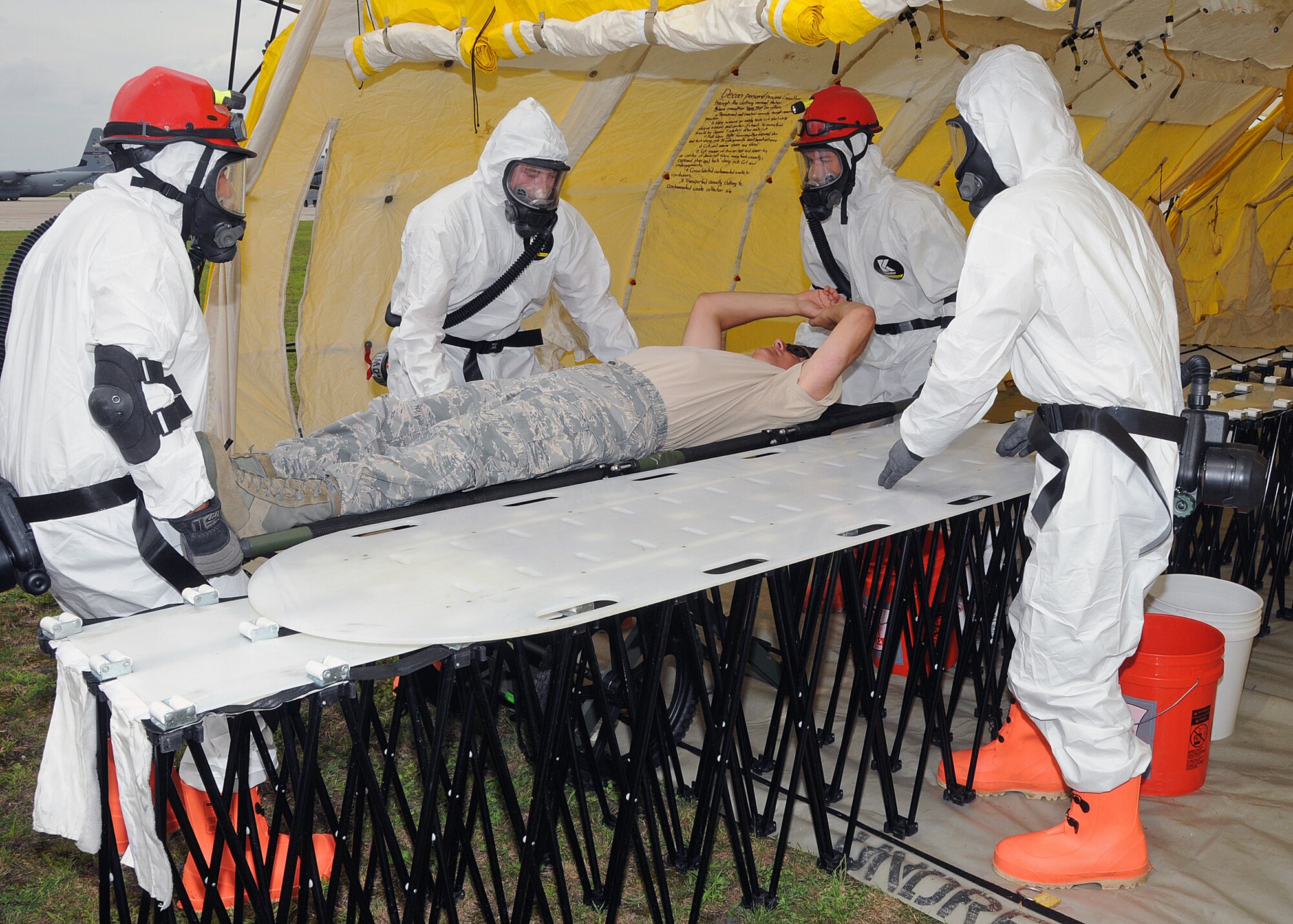 Members of the 143d Airlift Wing involved in the Region 1 Chemical, Biological, Radiological, Nuclear, High Yield Explosive Enhanced Response Force Package (CERFP) perform a training exercise to demonstrate the team's responsibilities and capabilities to potential new members and leadership. Colonel Arthur Floru (on stretcher),143d AW commander volunteered to play a victim for the exercise. The Region 1 CERFP is made up of members of the Air and Army National Guard from Maine, New Hampshire, and Rhode Island. National Guard Photo by Master Sgt Janeen Miller (RELEASED)