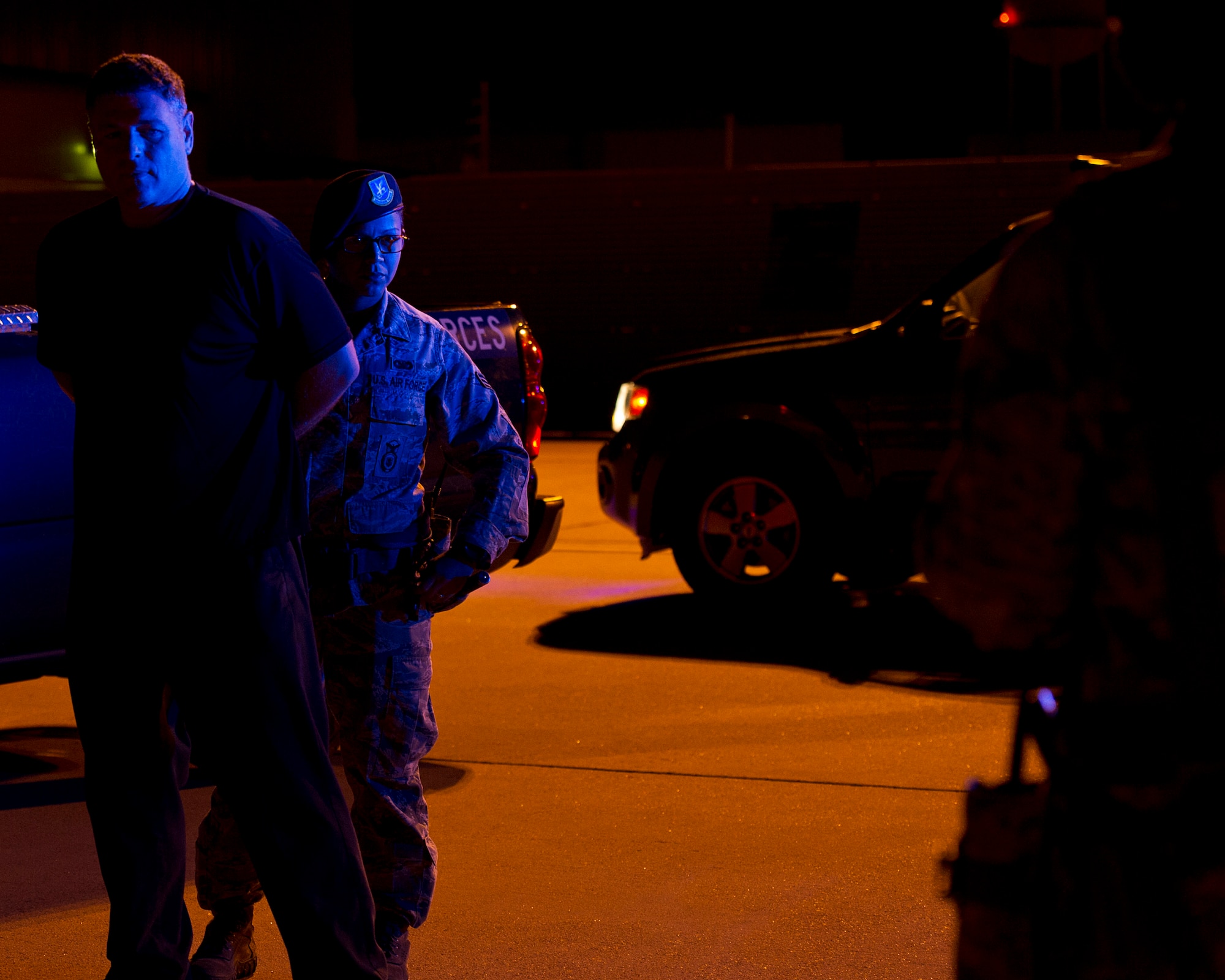 ALTUS AIR FORCE BASE, Okla. -- U.S. Air Force Senior Airman Laci Mendez, 97th Security Forces Squadron response force patrolman, listens to a fellow SFS member while restraining Nickey Jones, 97th SFS response force patrolman, during a simulated security incident on the flightline Aug. 27. The 97th SFS is responsible for guarding the base 24 hours a day. They are one of the various squadrons that work around the clock to ensure mission success at Altus AFB. (U.S. Air Force photo by Senior Airman Kenneth W. Norman / Released)