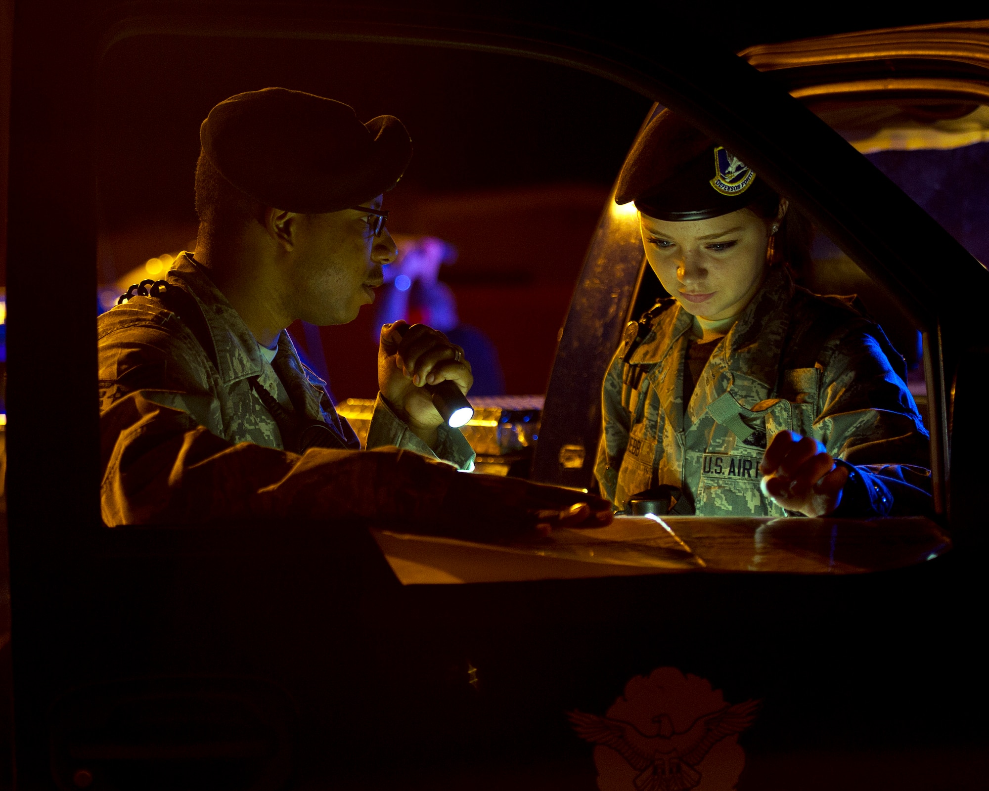 ALTUS AIR FORCE BASE, Okla. -- U.S. Air Force Staff Sgt. Matthew Boyd, 97th Security Forces Squadron flight sergeant for Charlie flight, and Airman 1st Class Sheridyn Webb, 97th SFS response force member, discuss coordinates on a map of the airfield during a simulated security incident on the flightline Aug. 27. The 97th SFS is responsible for guarding the base 24 hours a day. They are one of the various squadrons that work around the clock to ensure mission success at Altus AFB. (U.S. Air Force photo by Senior Airman Kenneth W. Norman / Released)