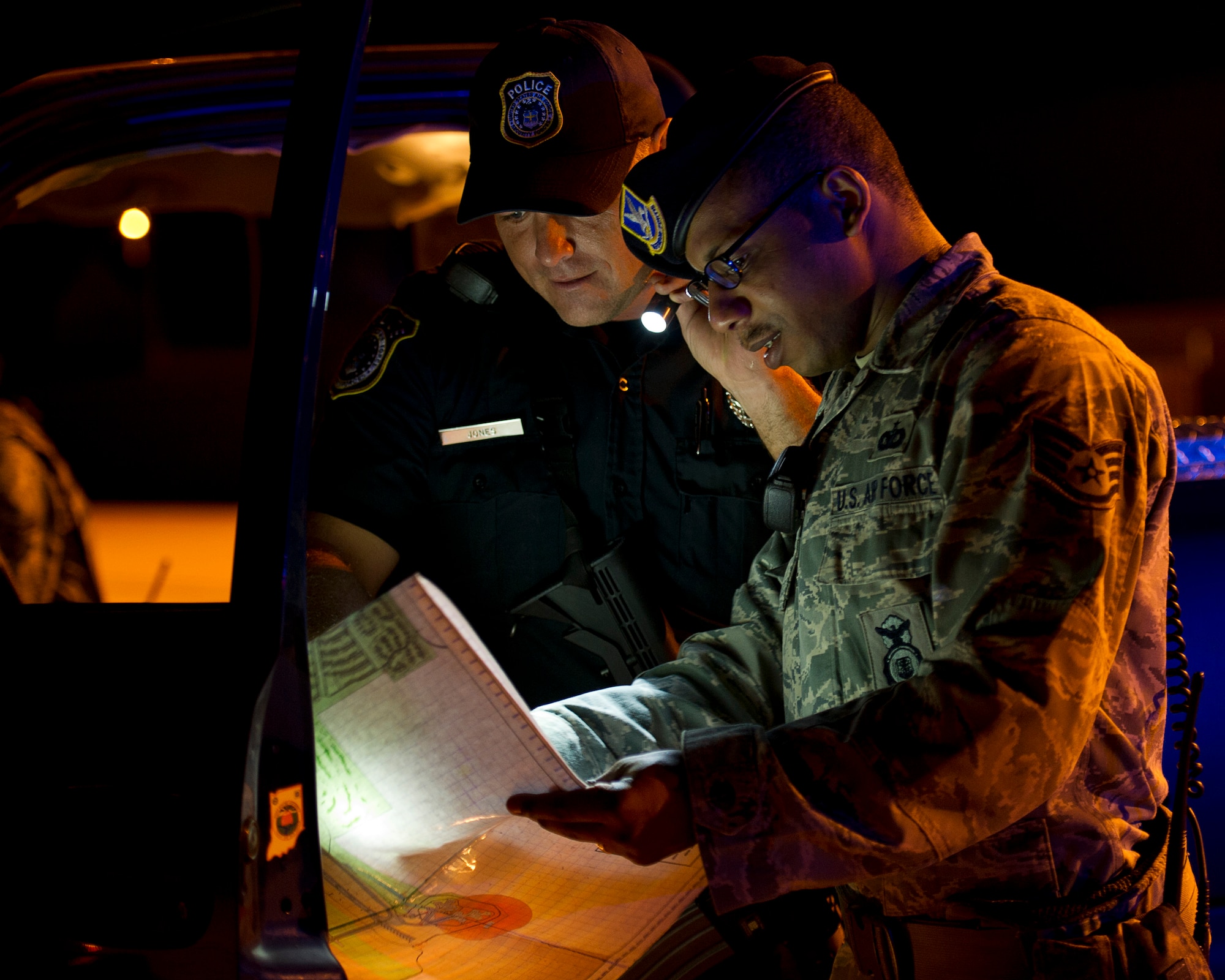 ALTUS AIR FORCE BASE, Okla. -- Nickey Jones, 97th Security Forces Squadron response force patrolman, and U.S. Air Force Staff Sgt. Matthew Boyd, 97th SFS flight sergeant of Charlie flight, look at a map of the airfield during a simulated security incident on the flightline Aug. 27. The 97th SFS is responsible for guarding the base 24 hours a day. They are one of the various squadrons that work around the clock to ensure mission success at Altus AFB. (U.S. Air Force photo by Senior Airman Kenneth W. Norman / Released)