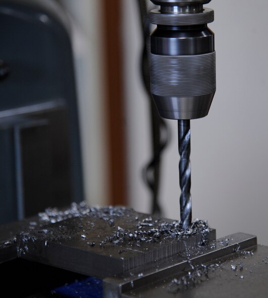 A manual mill drills holes into a piece of metal at the 2nd Maintenance Squadron Fabrication flight on Barksdale Air Force Base, La., Aug. 28, 2013. The metals technology flight is capable of creating tools and parts from raw materials for the flight to use. (U.S. Air Force photo/Airman 1st Class Andrew Moua)