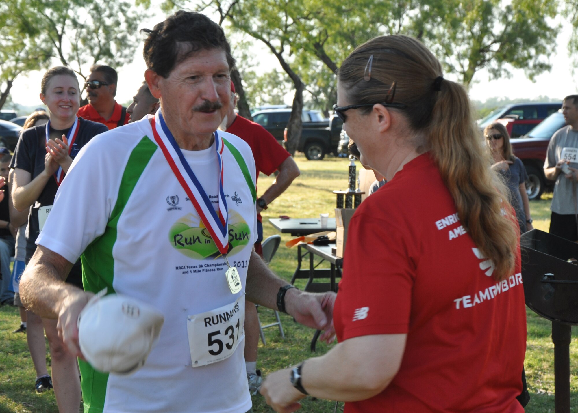 SAN ANGELO, Texas – Sgt. 1st Class Kristie Young, Army 344th Military Intelligence Battalion operations NCO in charge, presents  Retired Army Capt. Dr. Jerry Roach, Armydillo competitor, the 1st place medal for the 60  and over category in the  two-mile fun run during the 19th Annual Armydillo at the Spring Creek Marina and RV Park Aug. 24. Roach finished the run in 16 minutes and 3 seconds. (U.S. Air Force photo/ Airman 1st Class Joshua Edwards)